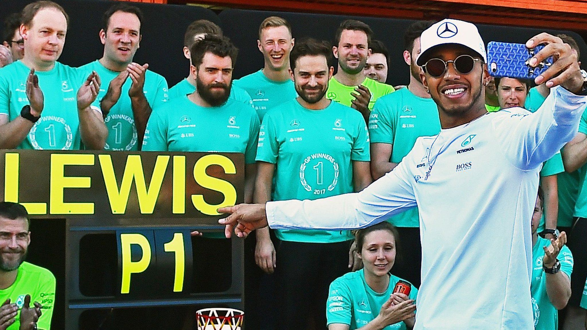 Lewis Hamilton celebrates with his team after the race