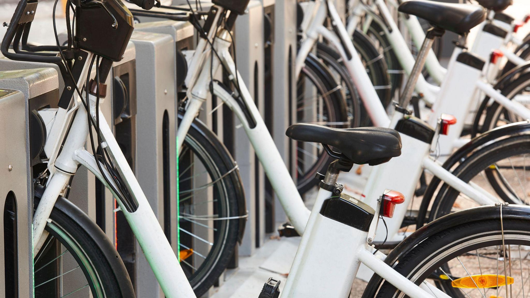 A rack full of white e-bikes