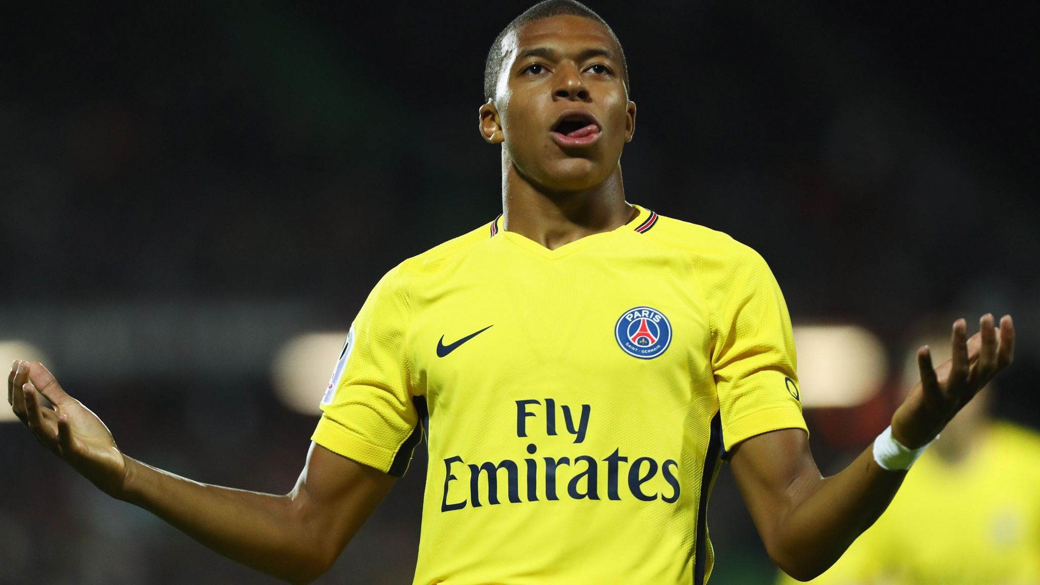 Mbappe celebrates with a shrug, while playing for PSG against Metz