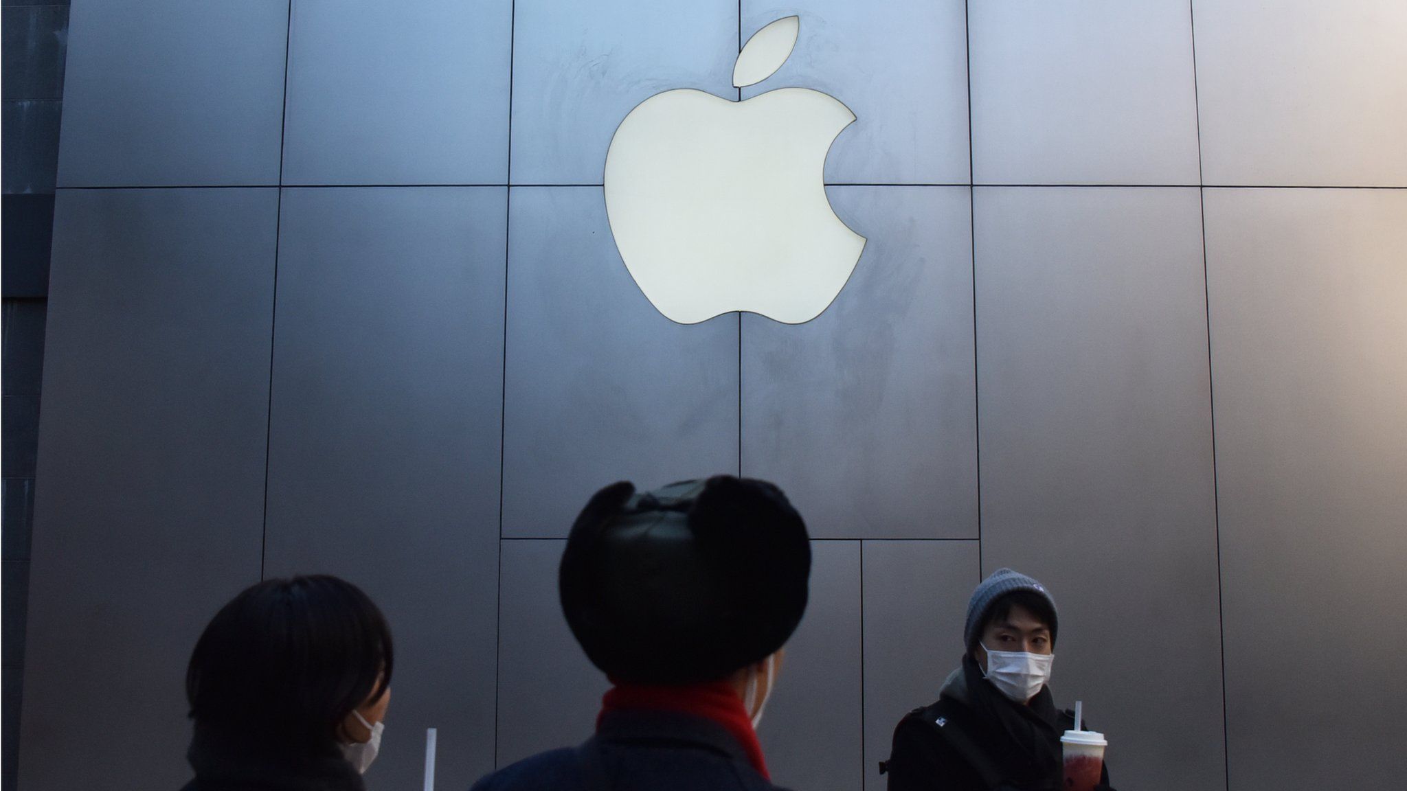 People walk past an Apple store in Beijing on December 11, 2018. -