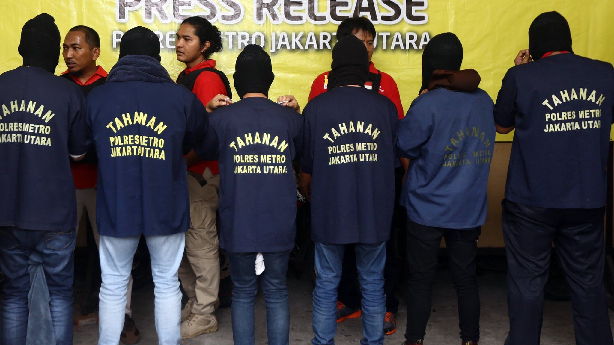 Indonesian police officers stand guard as men arrested in a raid are shown to the media during a press conference at a police station in Jakarta, Indonesia, 22 May 2017