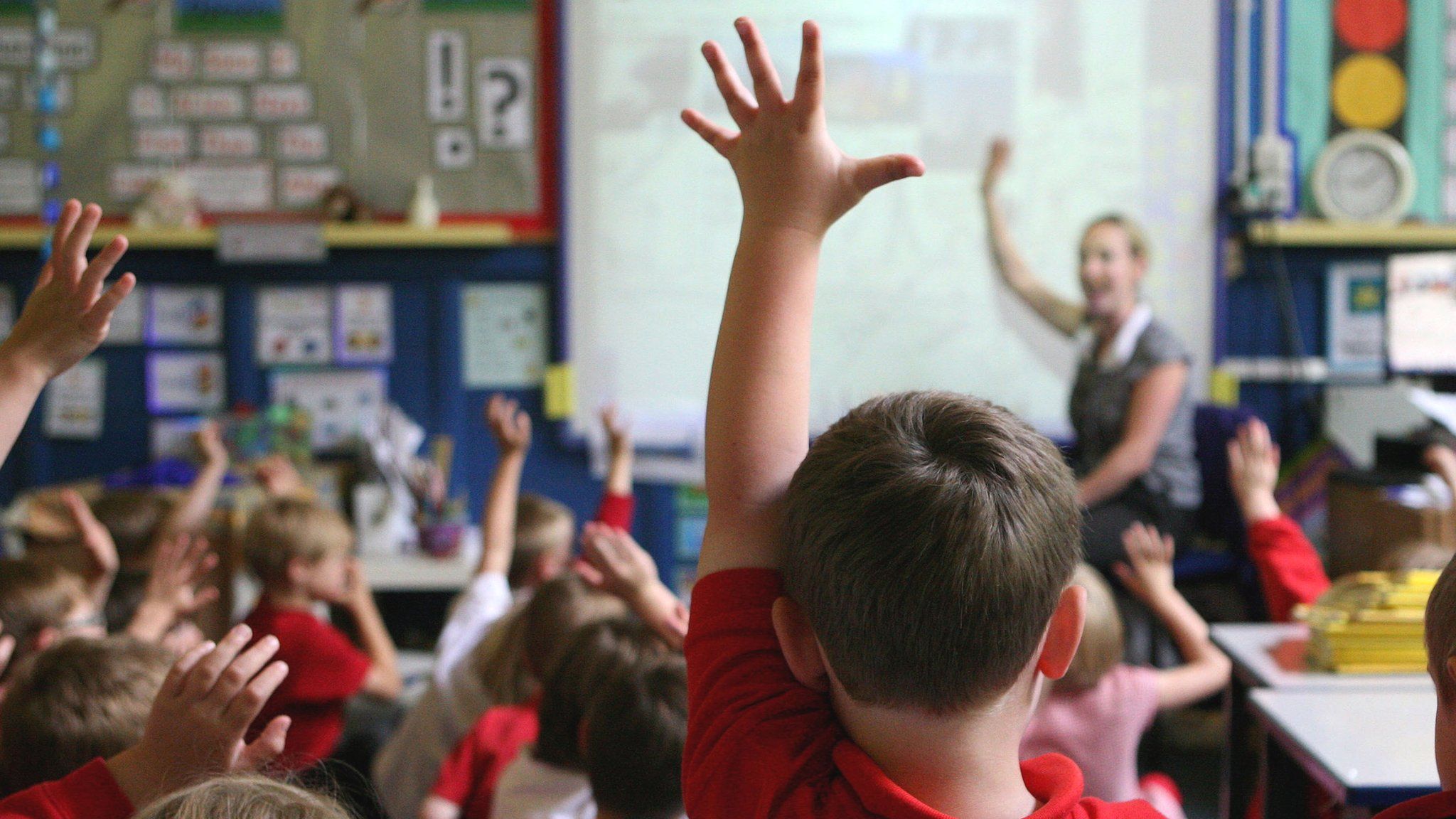 Children raising their hands in a classroom