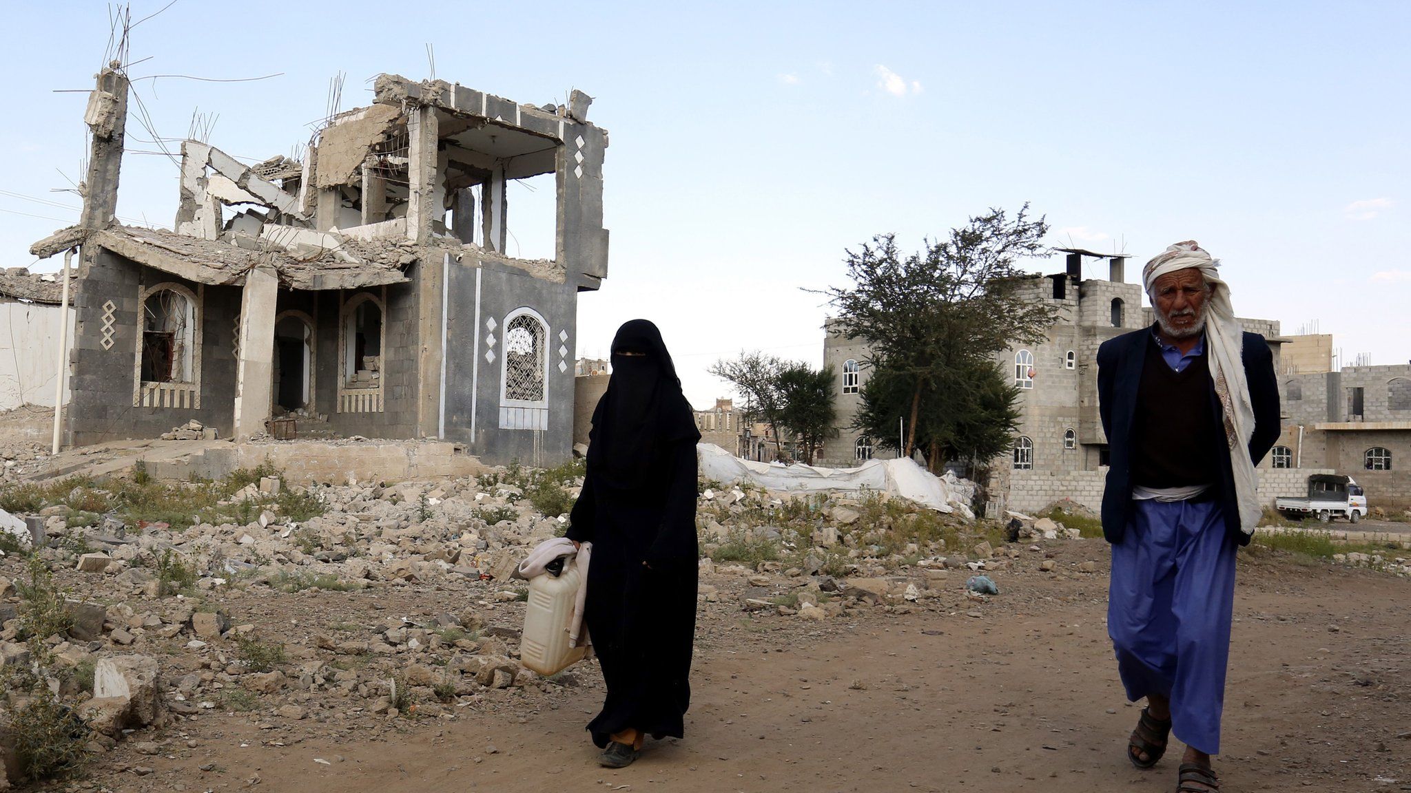 Yemenis walk past a destroyed building allegedly targeted by a previous Saudi-led airstrike, in Sana"a, Yemen, 08 December 2018.