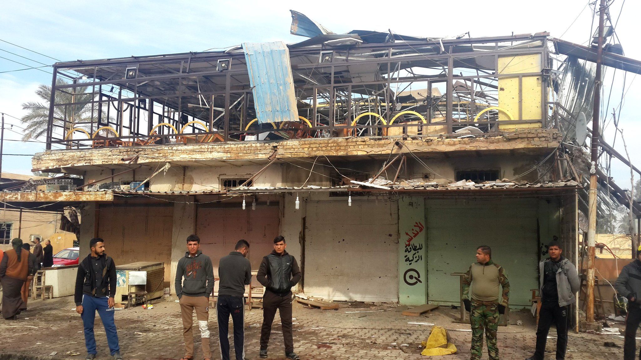 Iraqis gather outside a cafe in Muqdadiya that was attacked in a double bombing (12 January 2016)