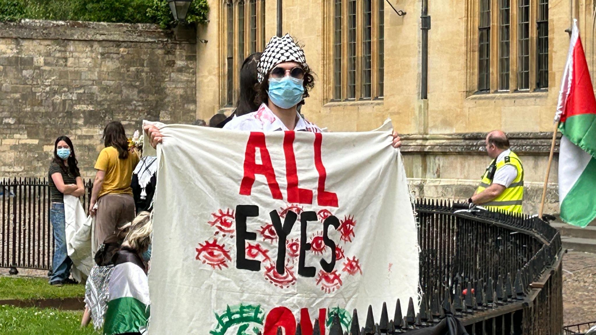 Protester hiding face holding pro-Gaza banner