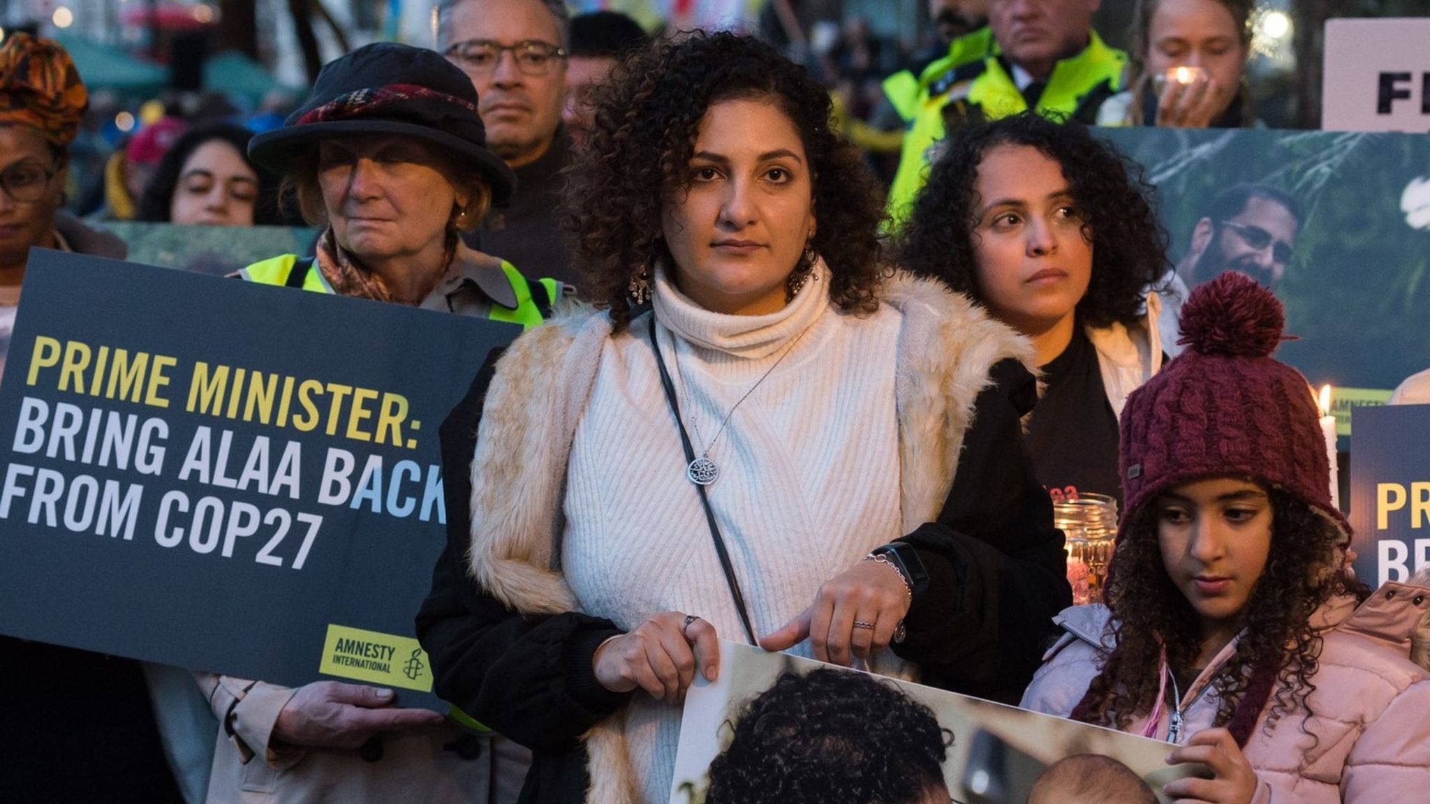 The sister of jailed British-Egyptian activist Alaa Abdel Fattah, Mona Seif (C) attends a nigh-time vigil in London to call on the British prime minister to secure his release at the COP27 summit (6 November 2022)