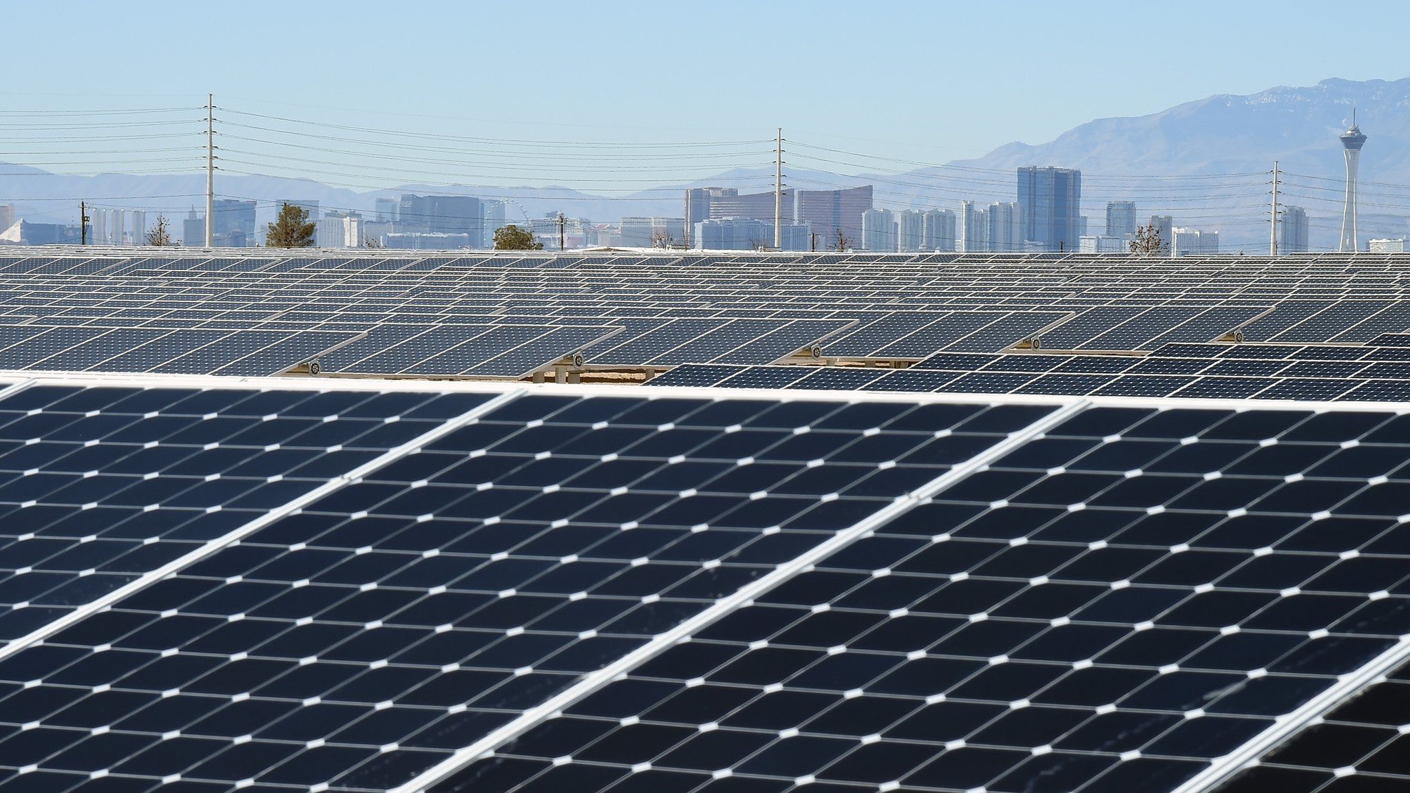 The Las Vegas Strip is shown behind solar panels during a dedication ceremony to commemorate the completion of the 102-acre, 15-megawatt Solar Array II Generating Station at Nellis Air Force Base on February 16, 2016 in Las Vegas, Nevada.