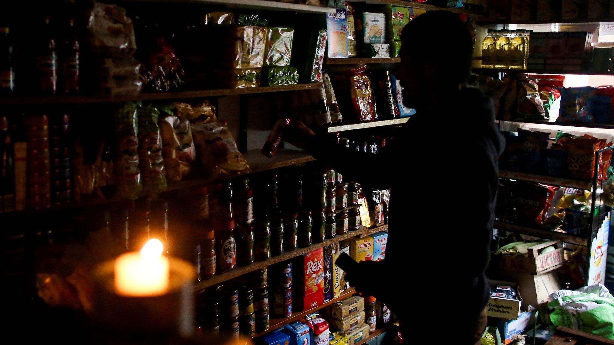 A shop vendor works by candlelight in Buenos Aires, Argentina