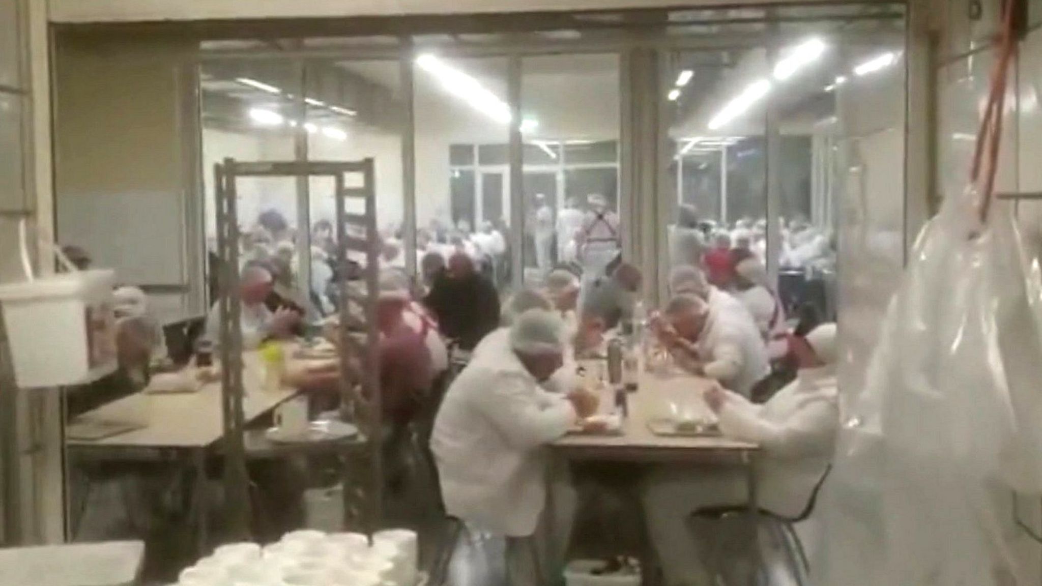 Footage from inside the canteen shows workers sitting together without social distancing