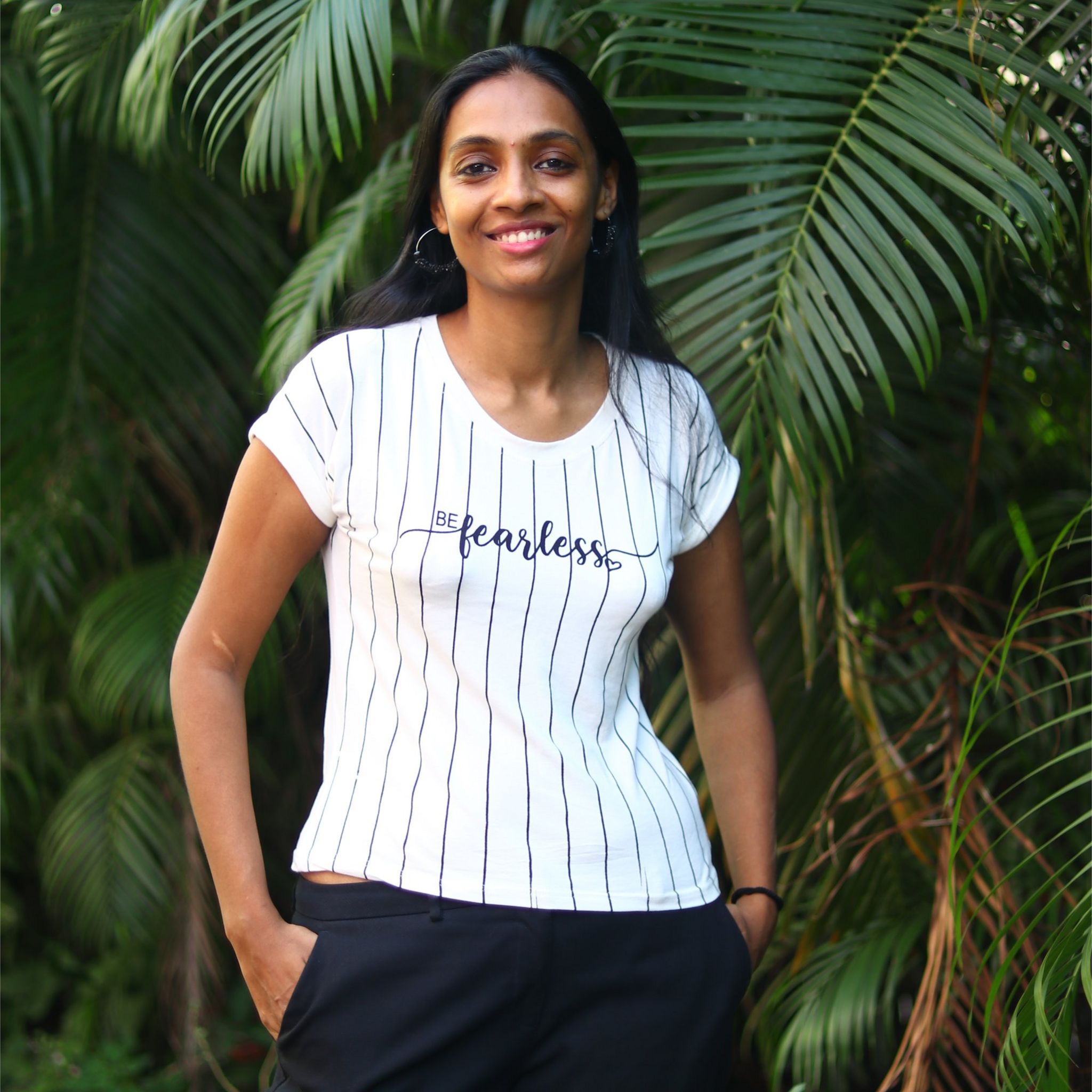 Pallavi standing by a tree with a t-shirt saying 'fearless' on it