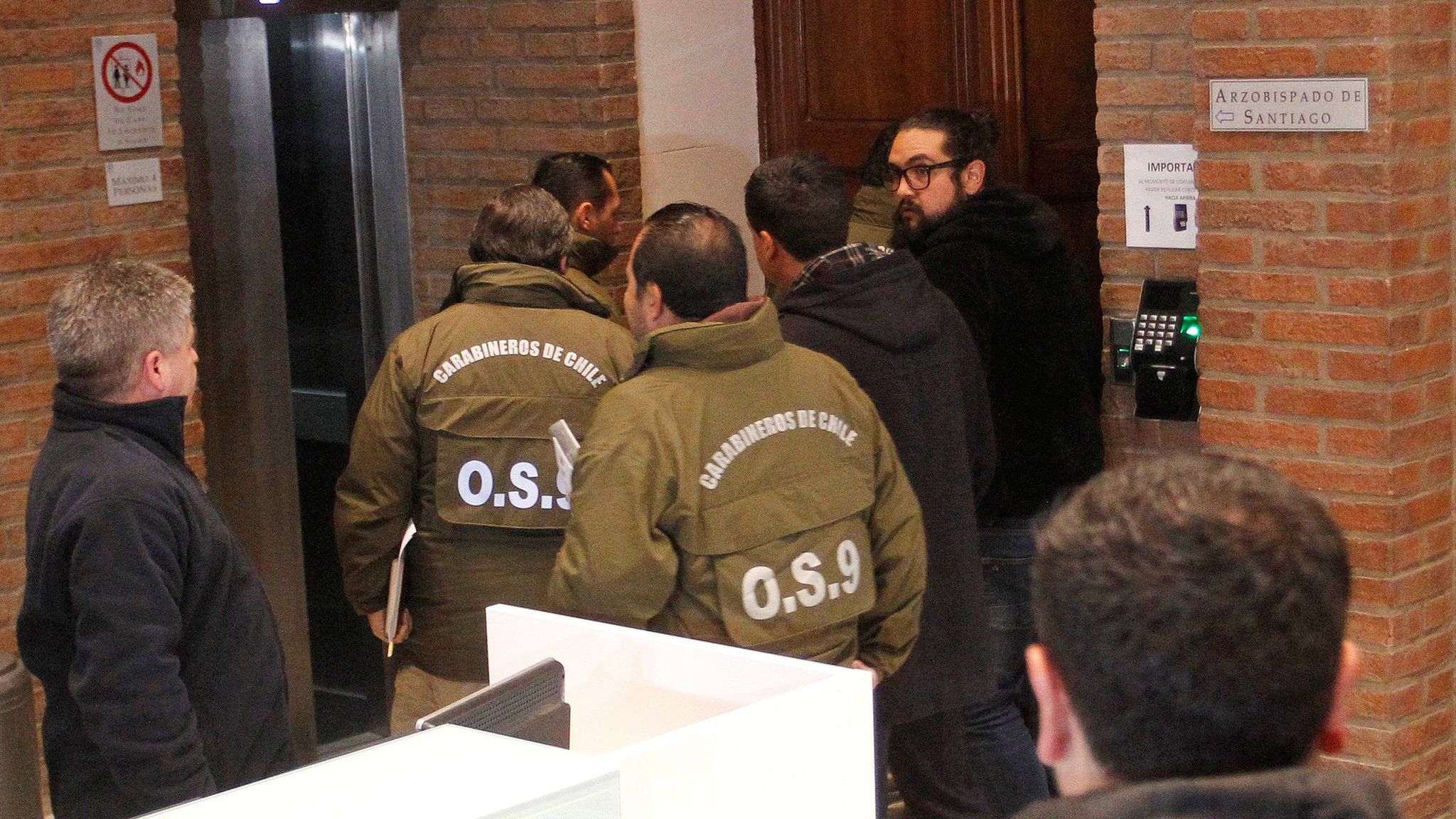 Chilean police officers are seen during the confiscation of the documents inside the office of the Ecclesiastical Court of the archdiocese of Santiago, Chile, June 13, 2018.