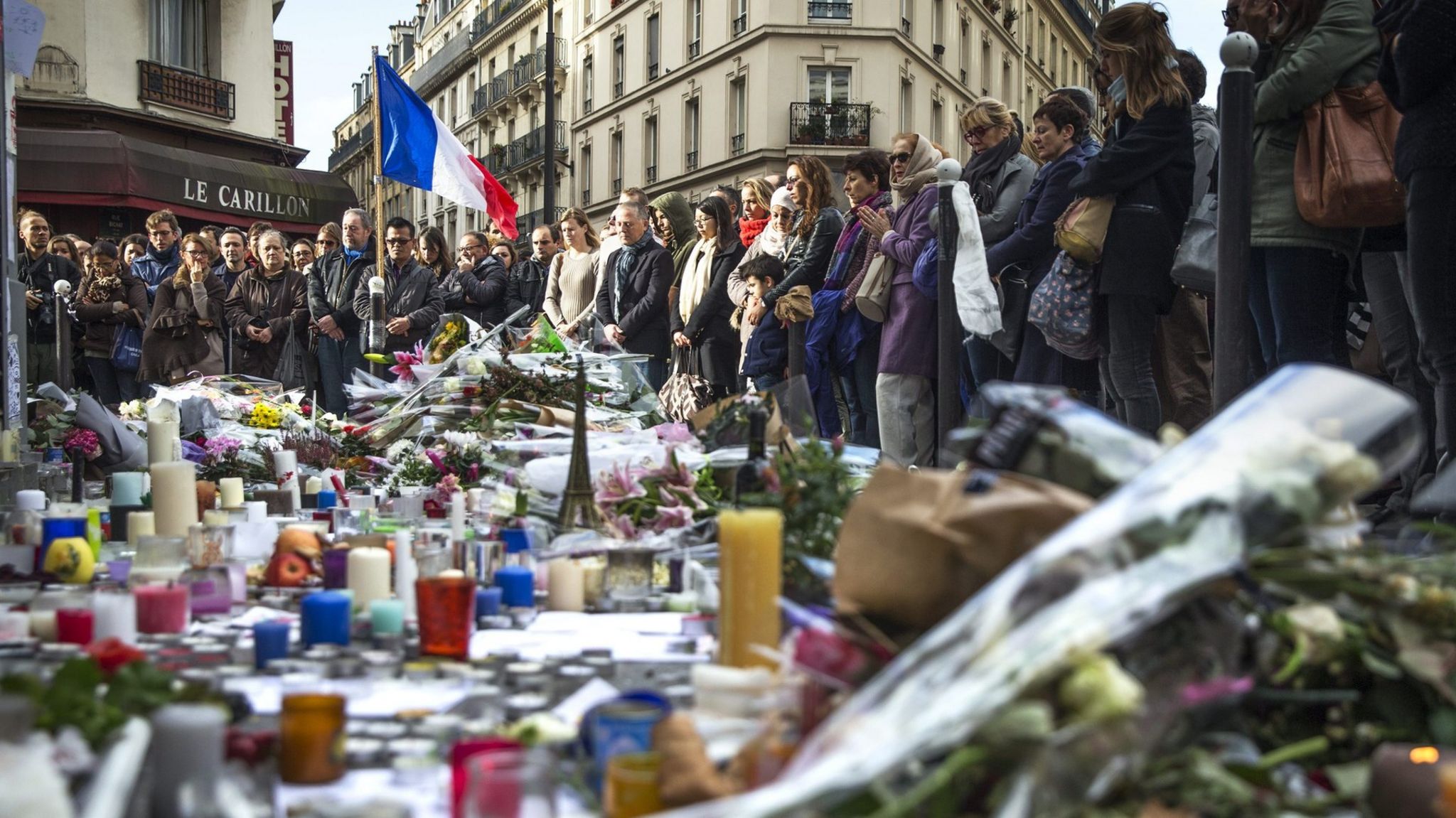 People observe a minute of silence at the Carillon and Le Petit Cambodge in Paris, (16 November 2015)