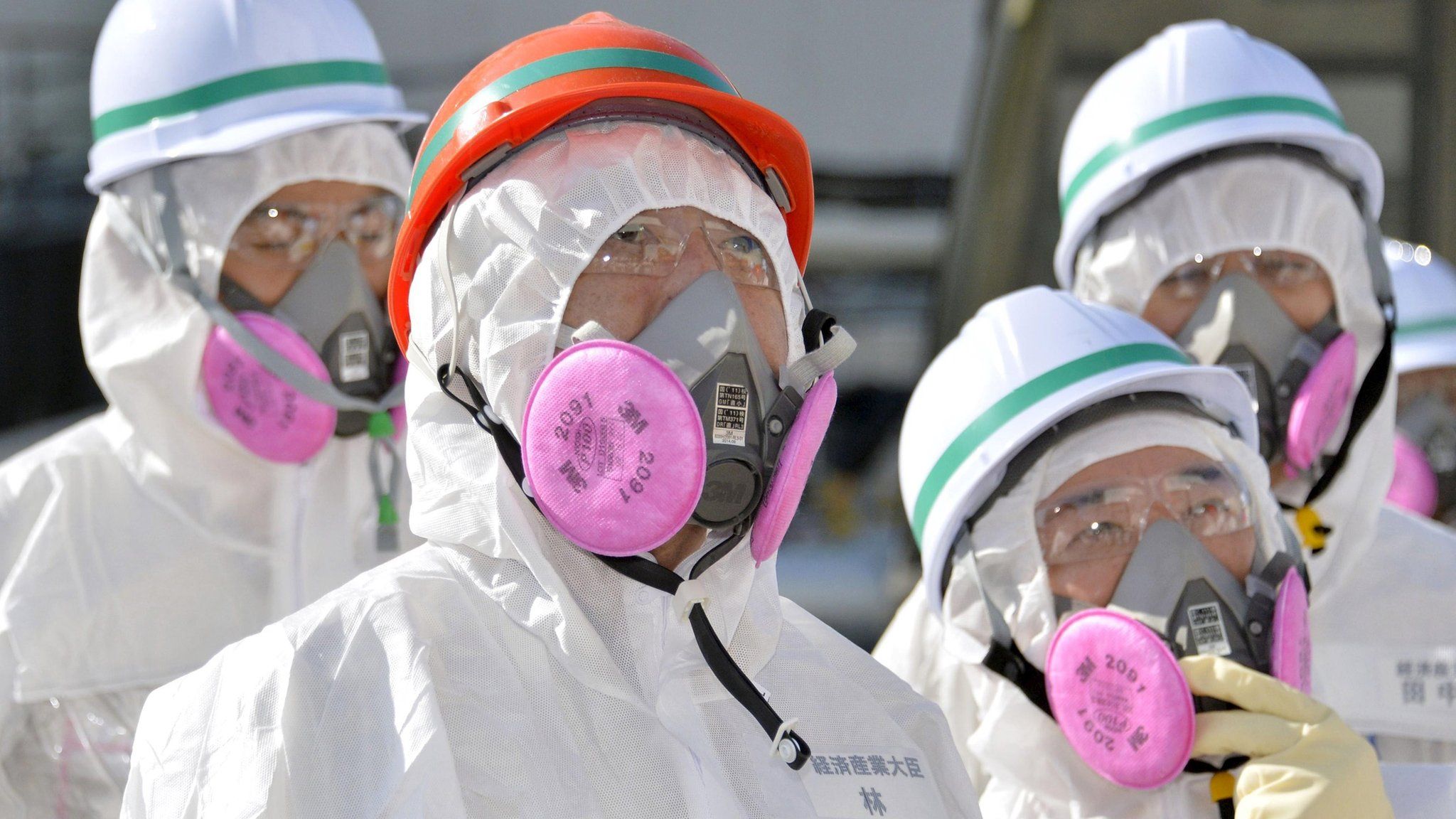 Japan's new Economy, Trade and Industry Minister Motoo Hayashi (2nd left) wearing a protective suit and a mask at the Fukushima plant