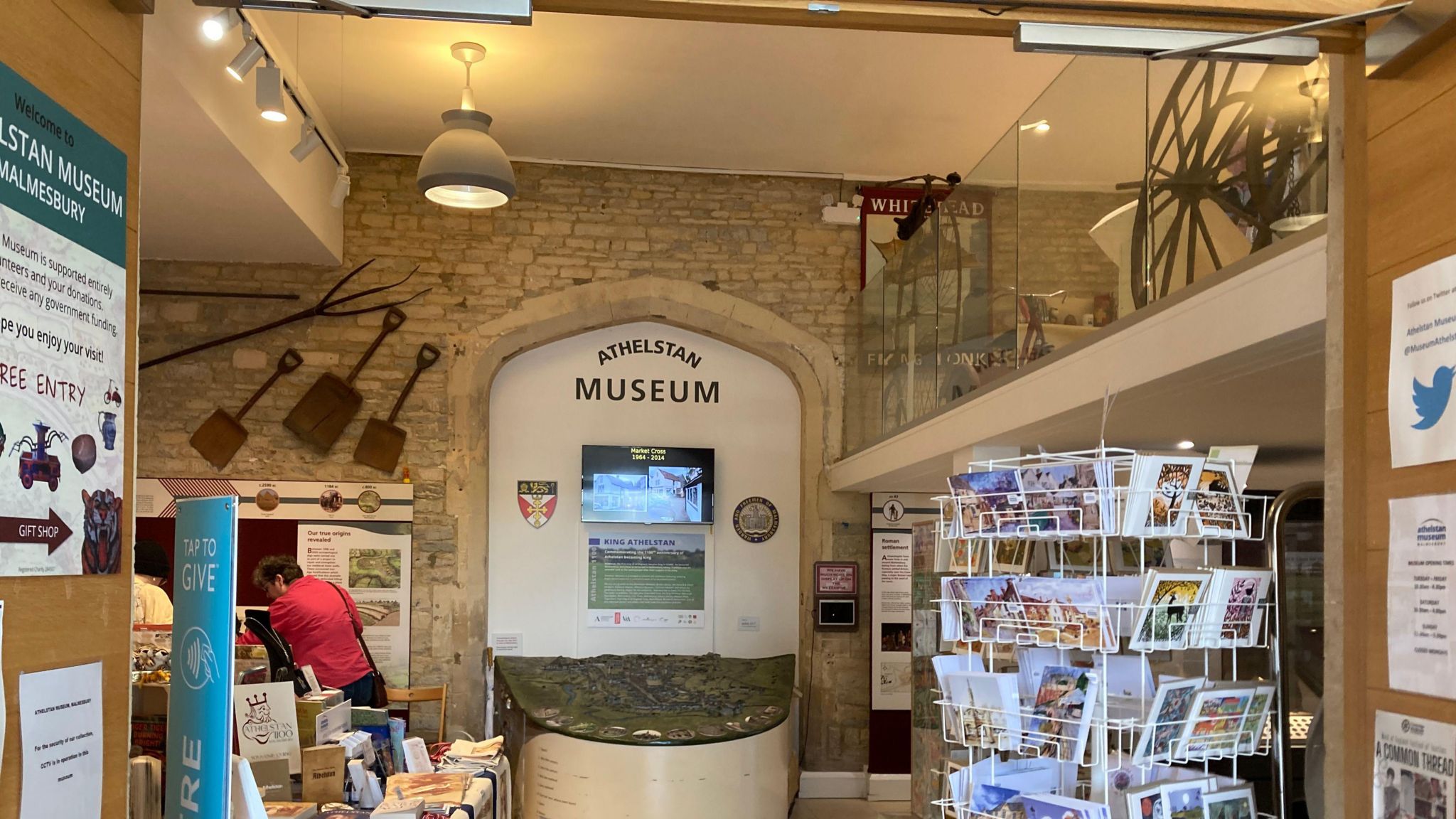 The entrance to the museum, with the small shop to the side, a model of the town and a rack of postcards