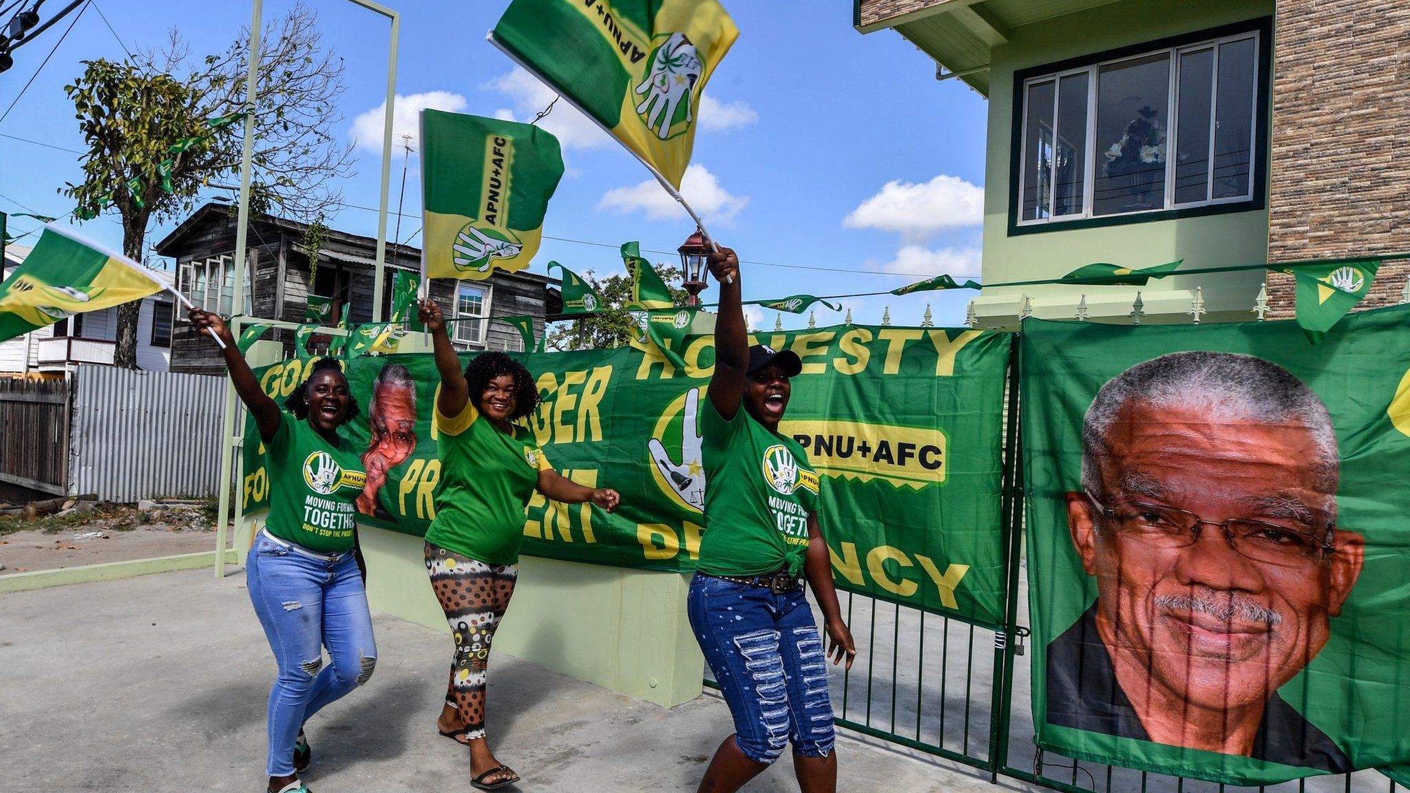 Supporters of presidential candidate David Granger, of the National Unity and Alliance for Change (ANPU-AFC) party, cheer and wave flags in front of their house in Georgetown, Guyana, on 1 March, 2020.