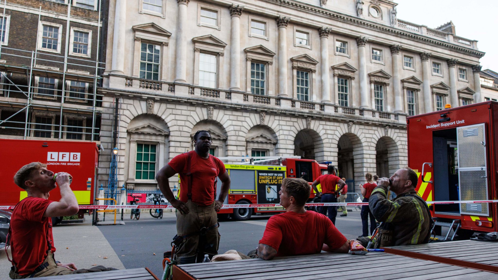 Firefighters take a break as they attend a fire on the roof of Somerset House in London