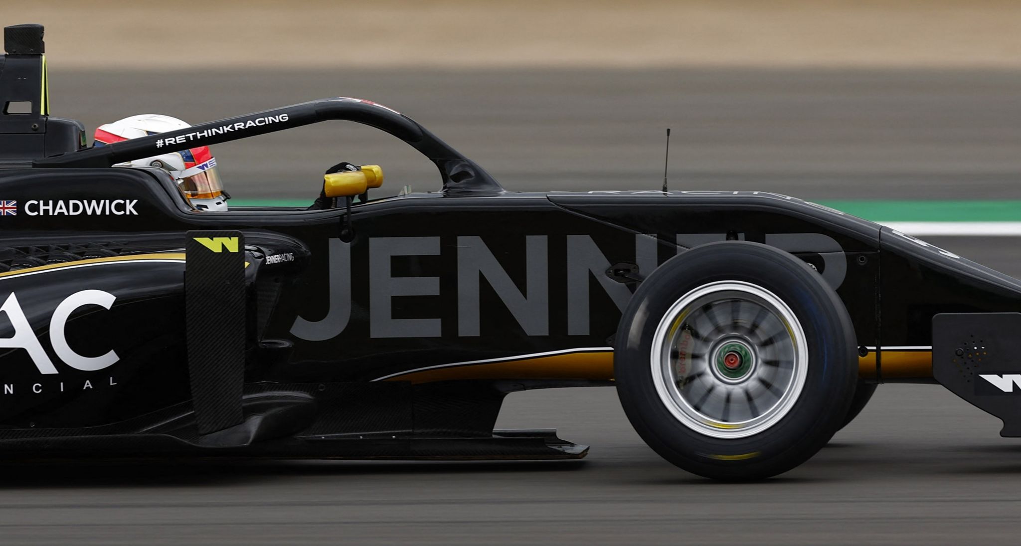 Side view of a black F1 racing car with the halo device