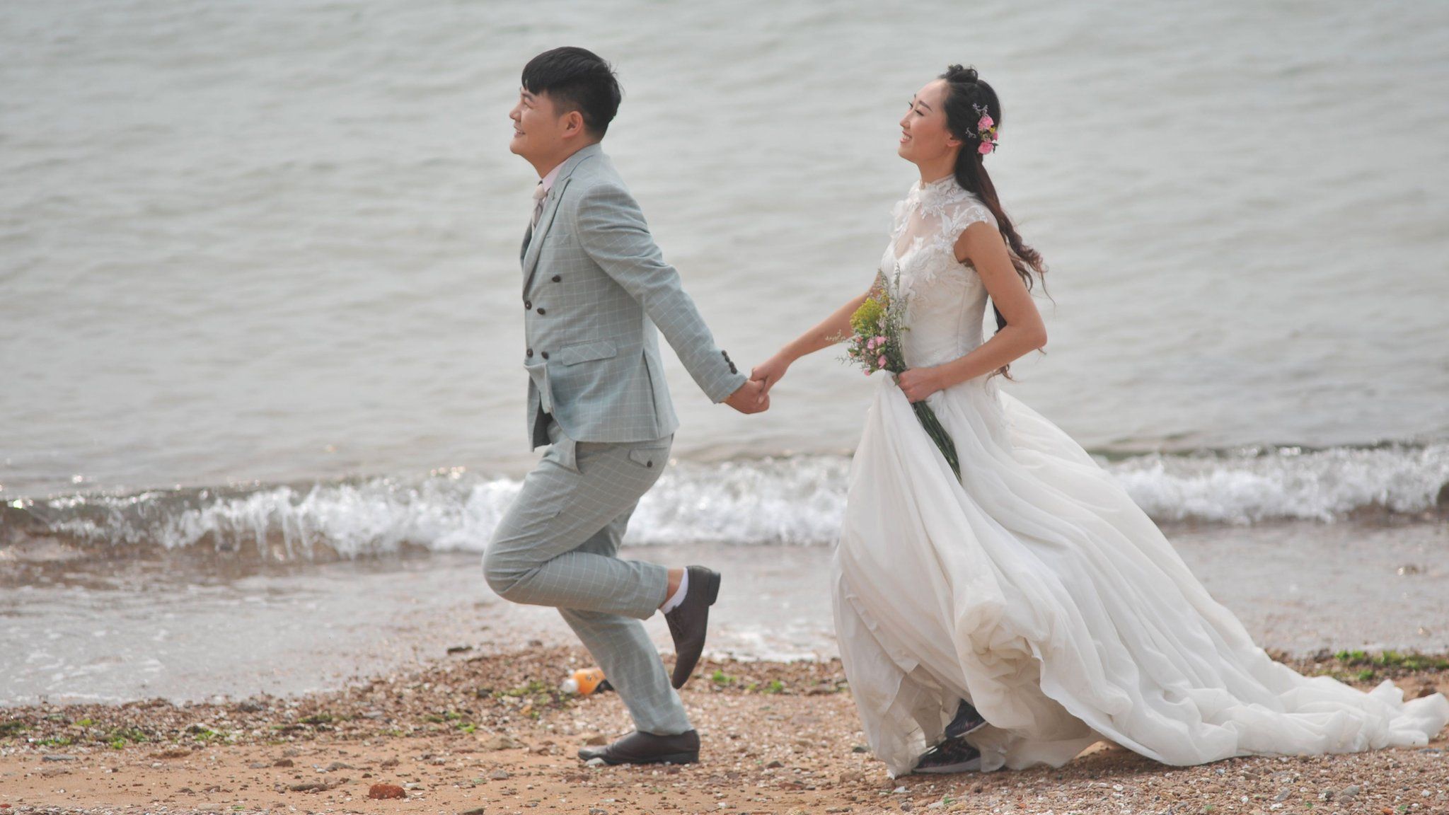 A couple take wedding photos by the sea at the Eight Great Passes (aka Ba Da Guan) on October 12, 2016 in Qingdao, Shandong Province of China