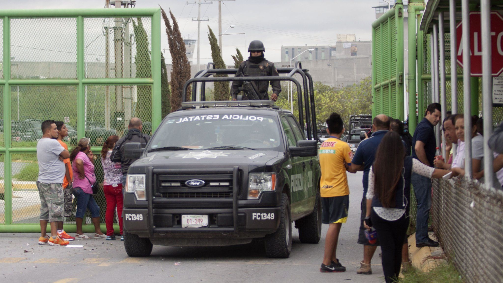 Armed police guard the main gate at Cadereyta prison in Mexico after a riot