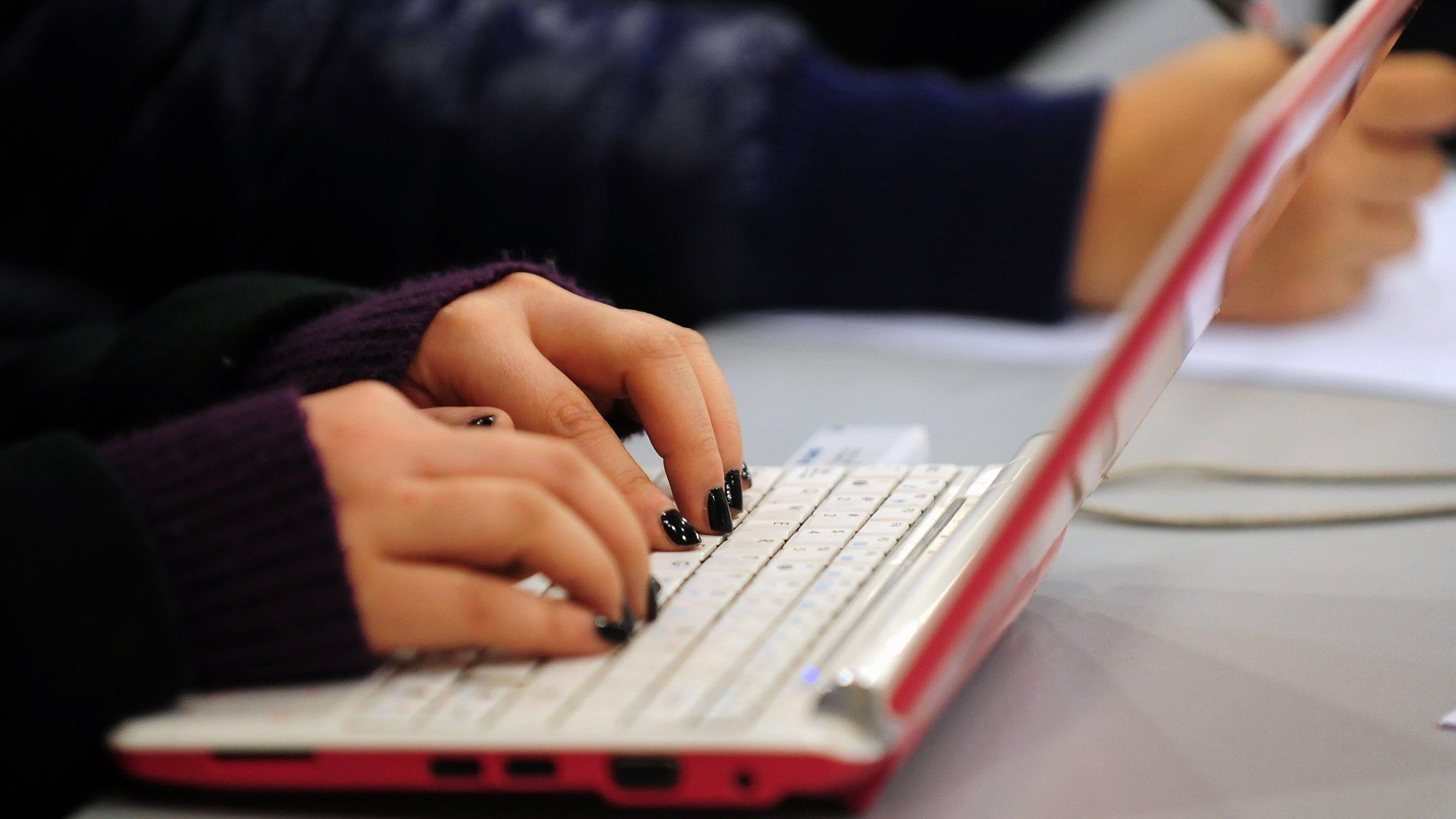 Woman's hands tying on laptop keyboard
