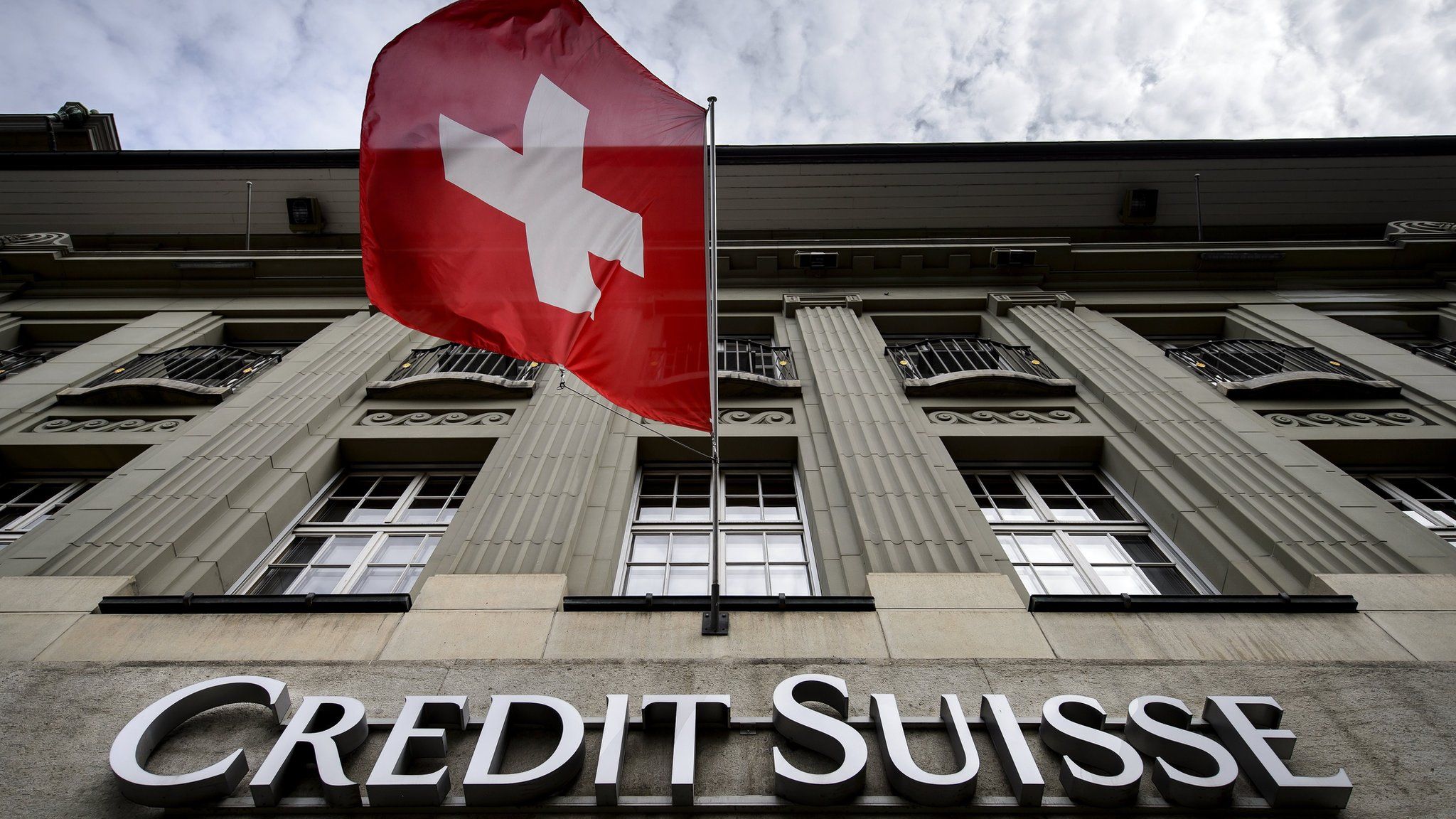 Sign on Credit Suisse building with Swiss flag