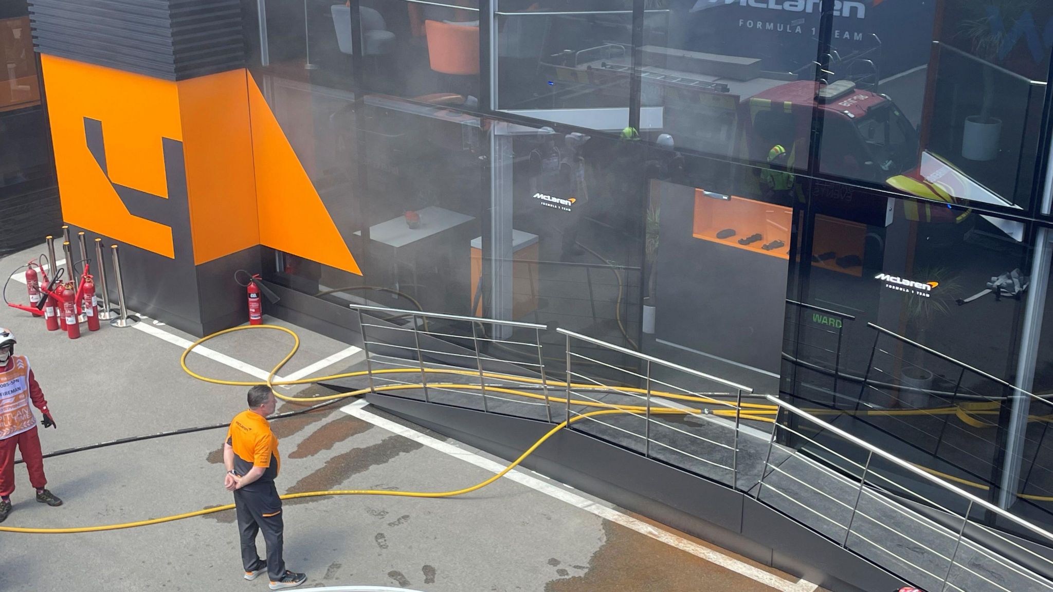 McLaren team boss Zak Brown stood outside the team's hospitality area as firefighters deal with the fire incident before final practice