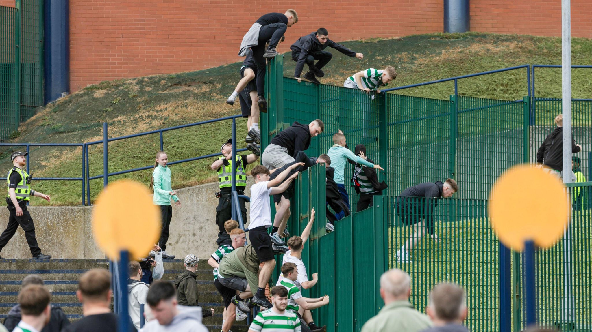 Fans climbing fence outside Hampden