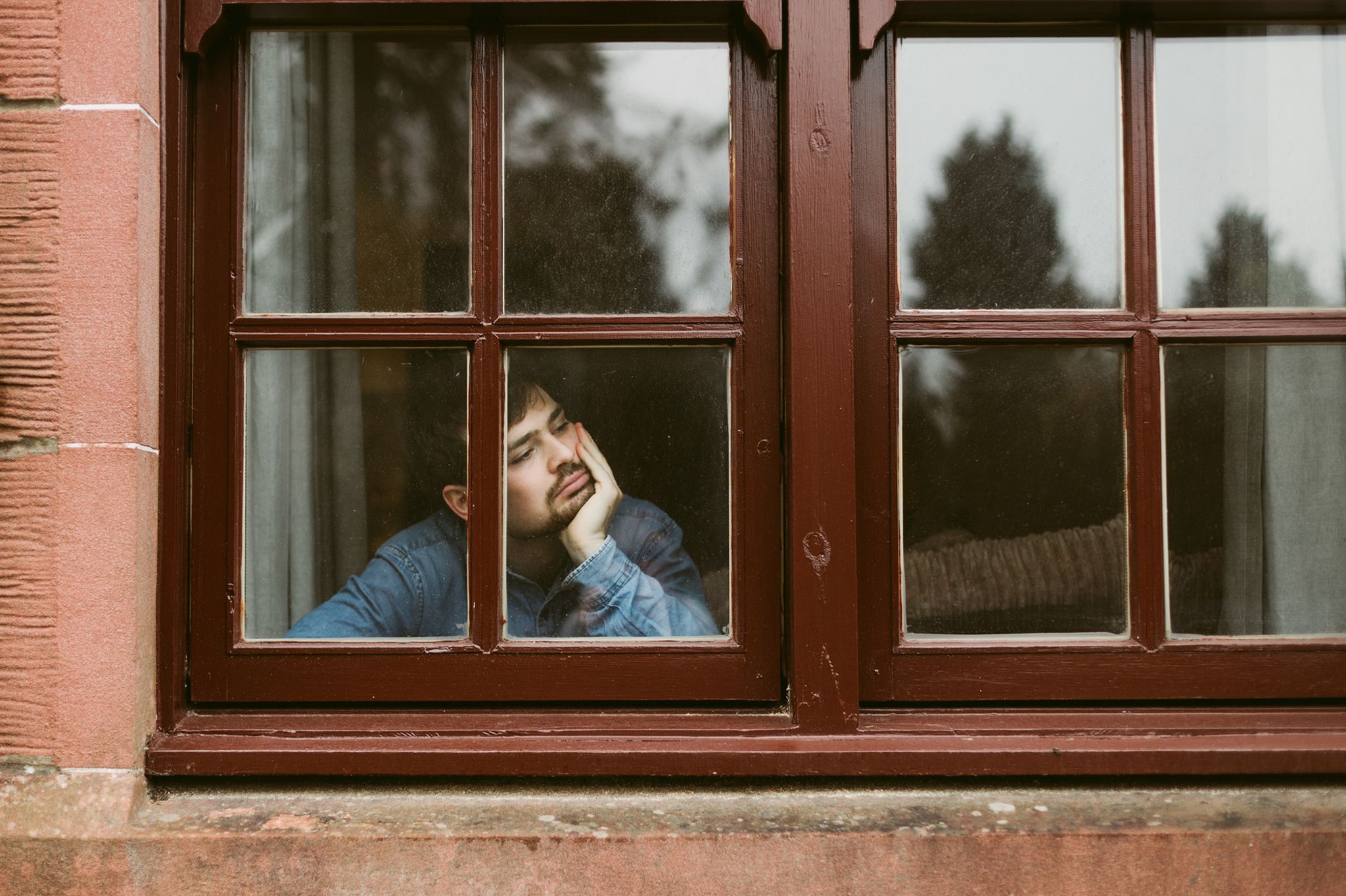 Bored man looking out of window