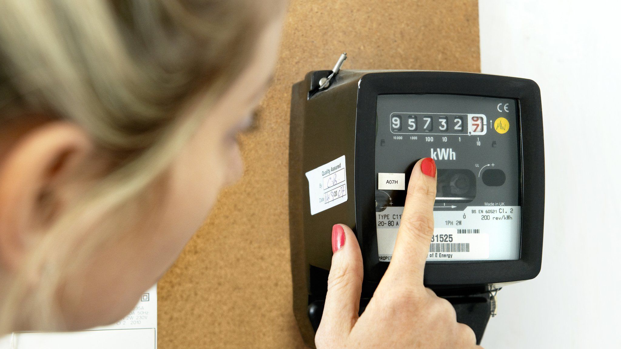 A woman points at an energy meter