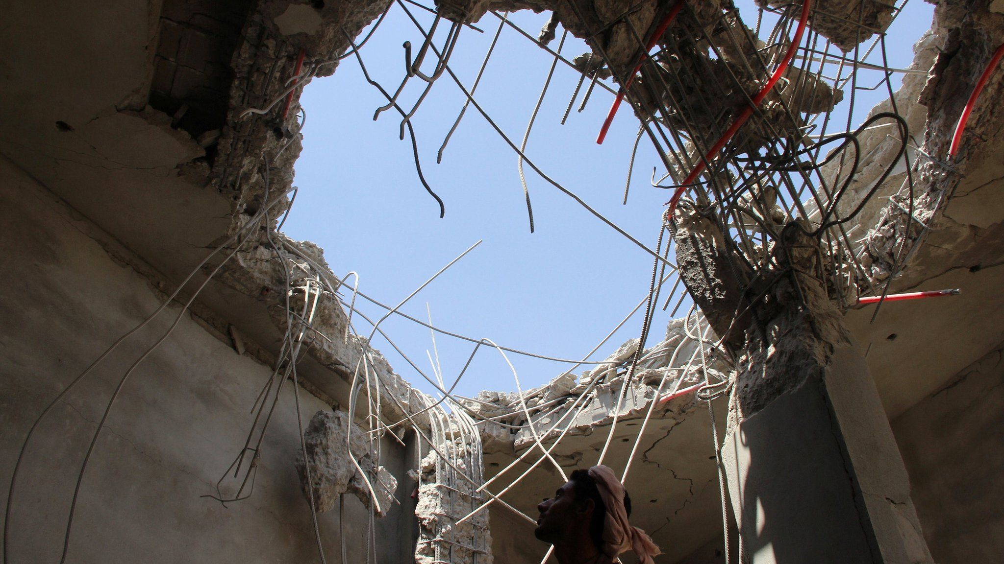 Man inspects building damaged in reported Saudi-led coalition air strike in Saada province, Yemen (10 September 2016)