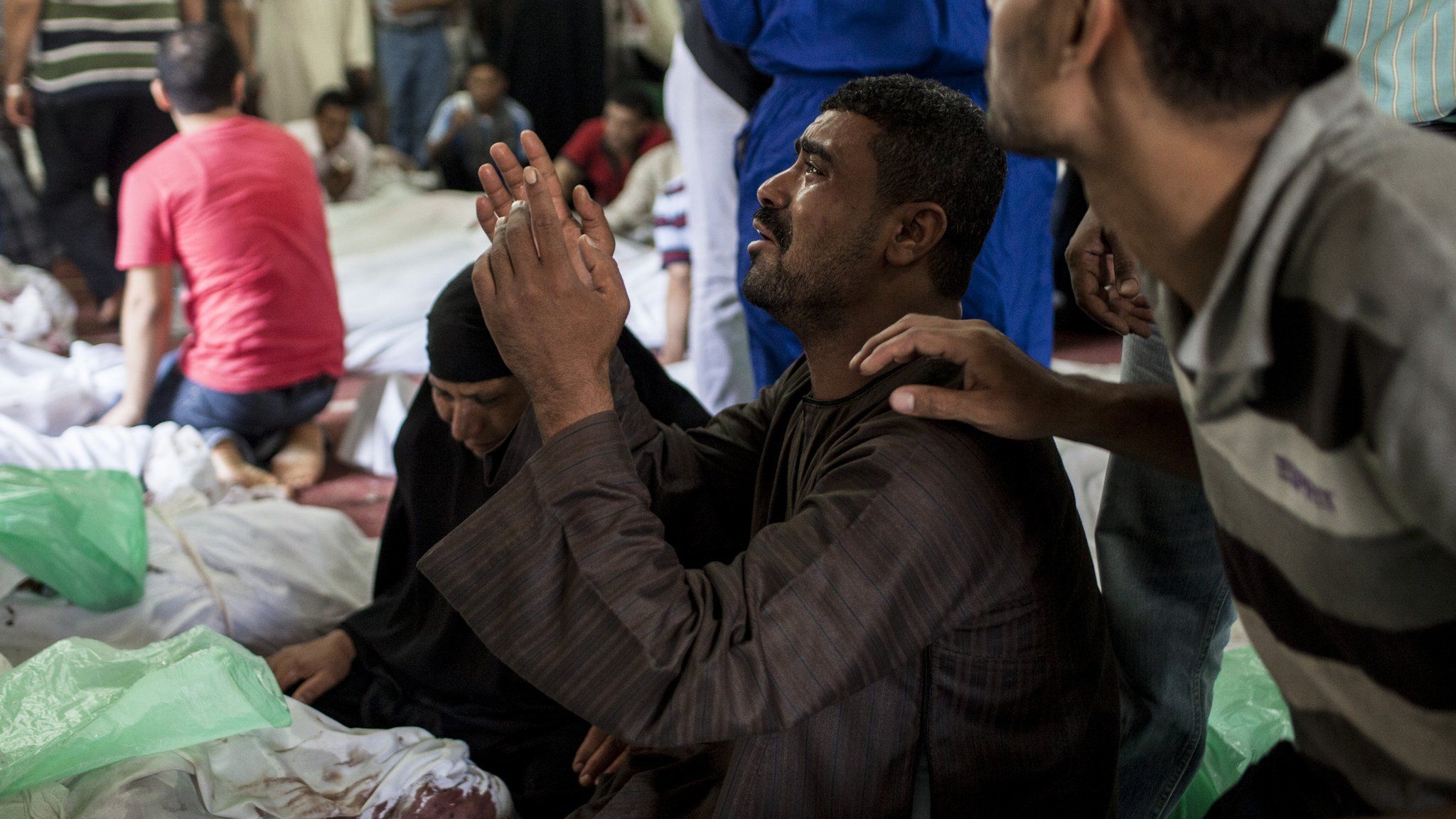 An Egyptian man identifies the body of a family member killed during a crackdown by Egyptian security forces in Cairo, Egypt (15 August 2013)