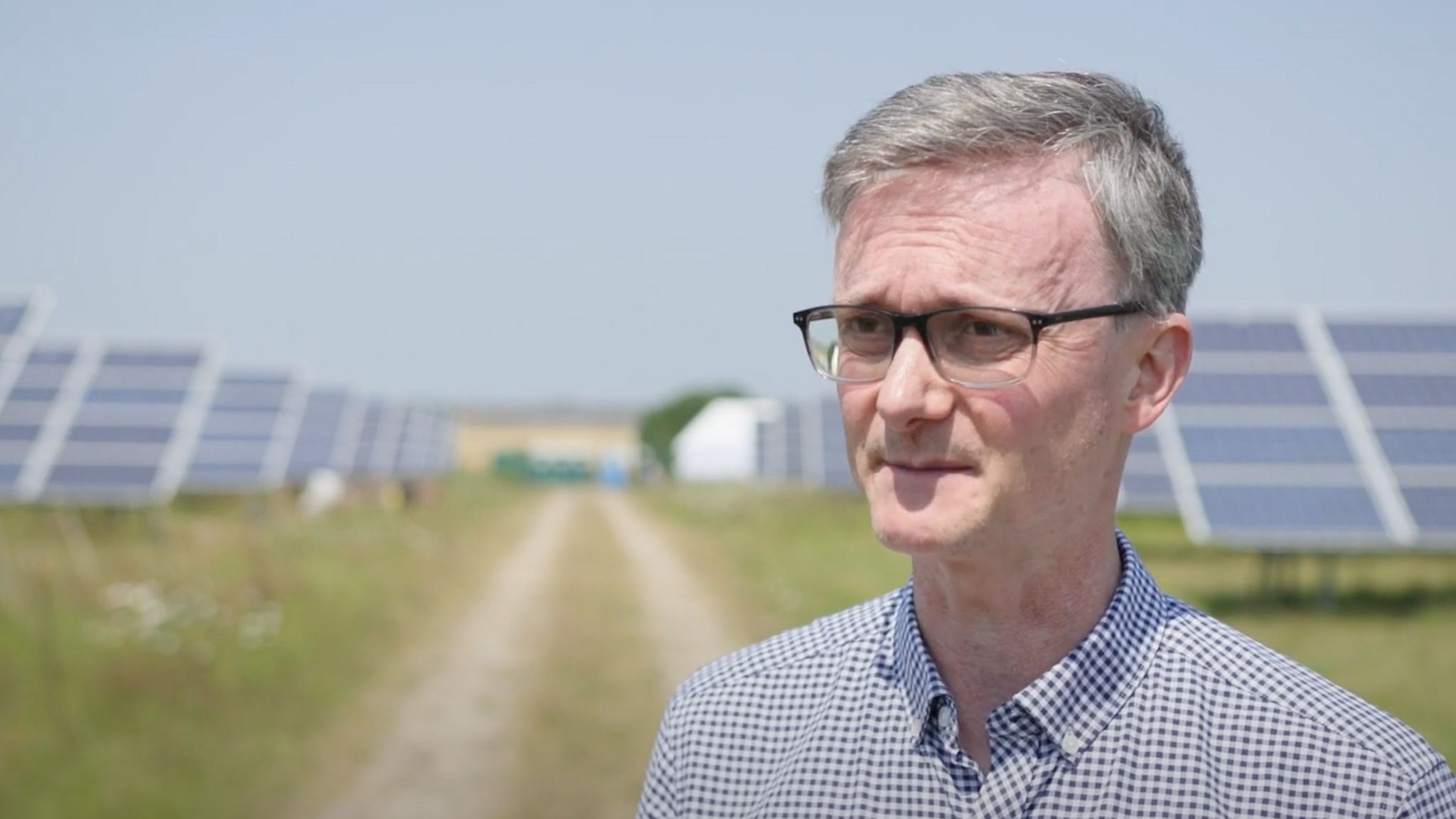 Chris Hewett of Solar Energy UK stands in front of a field of solar panels