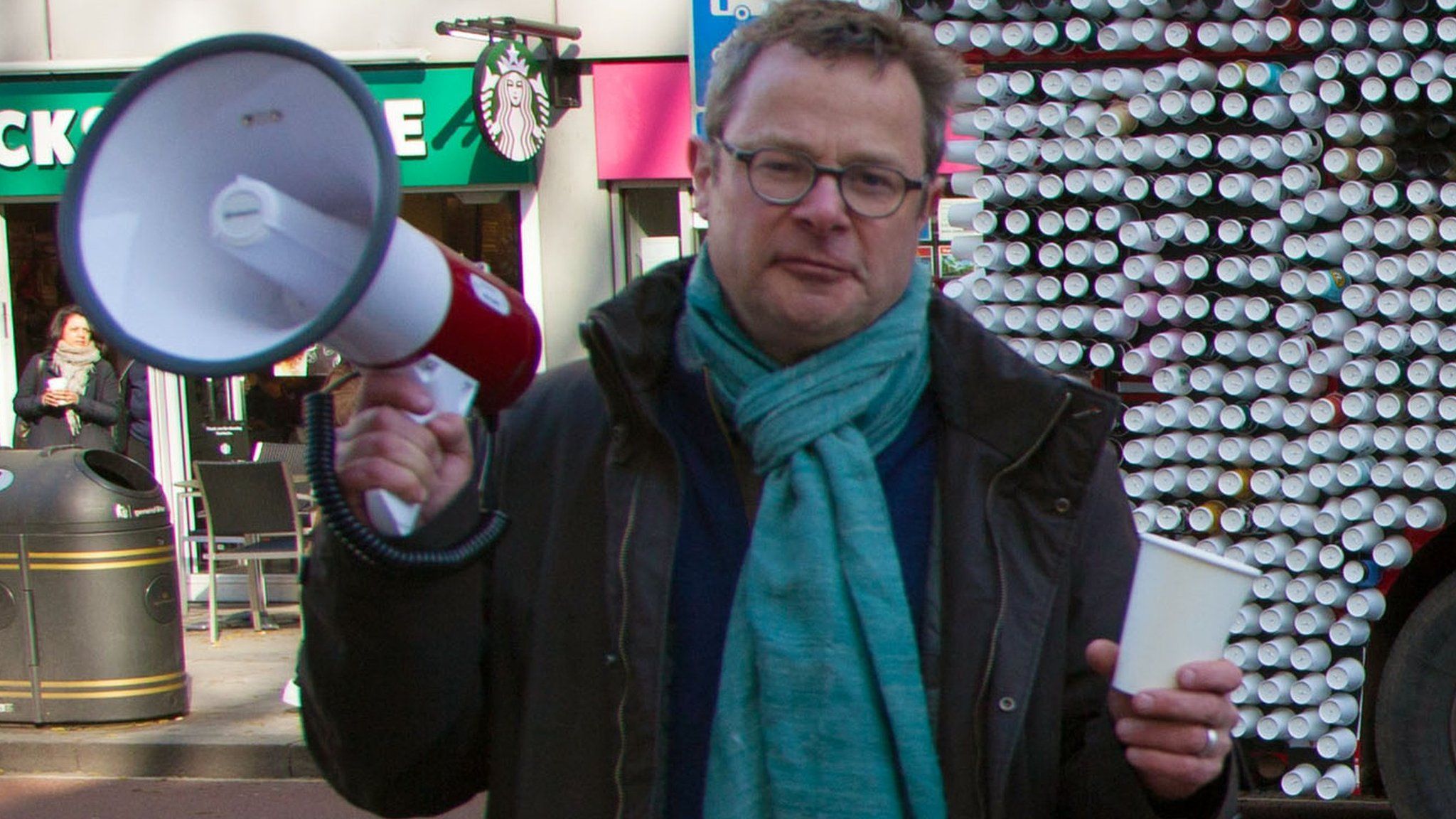 Hugh Fearnley-Whittingstall standing in front of a bus made of cups