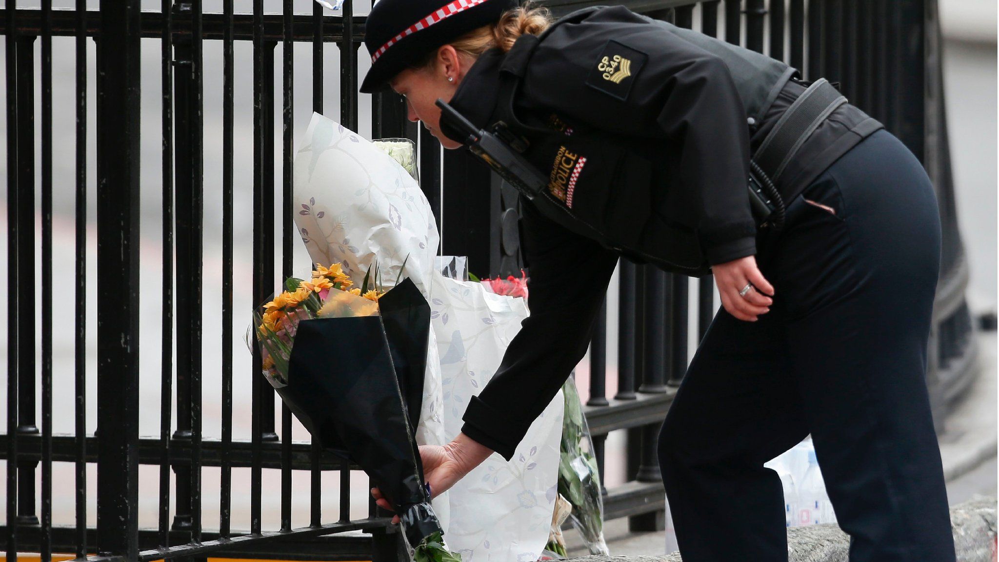 A police officer prepares to lay flowers near London bridge