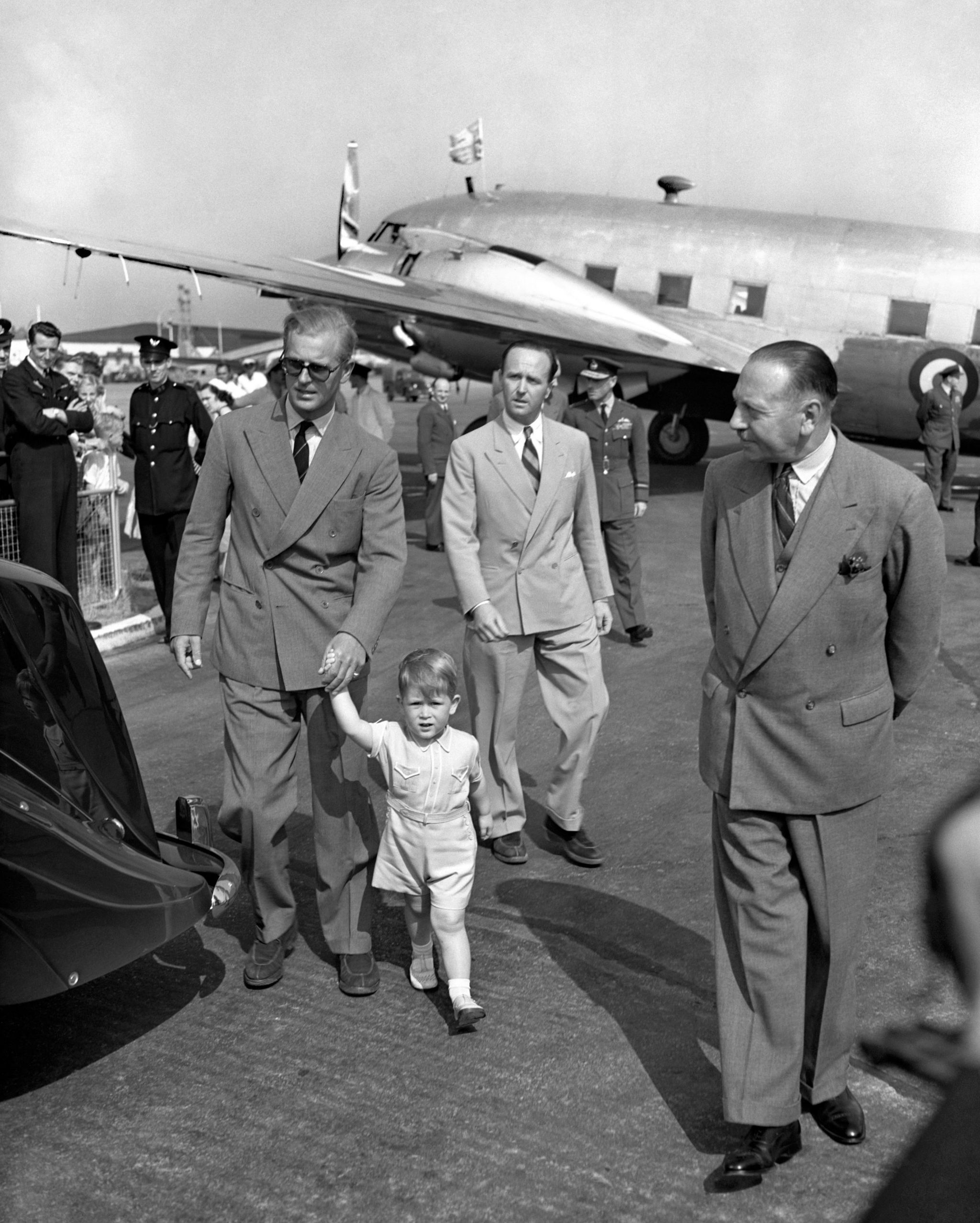 Prince Charles leading his father by the hand after the Duke of Edinburgh arrived home from Malta on 21 July 1951.