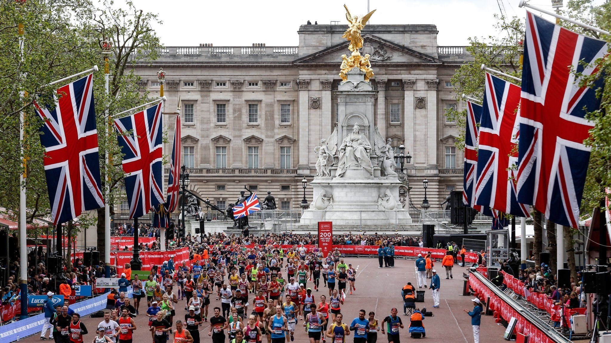 Runners heading down The Mall during the 2019 London Marathon with Buckingham Palace in the background