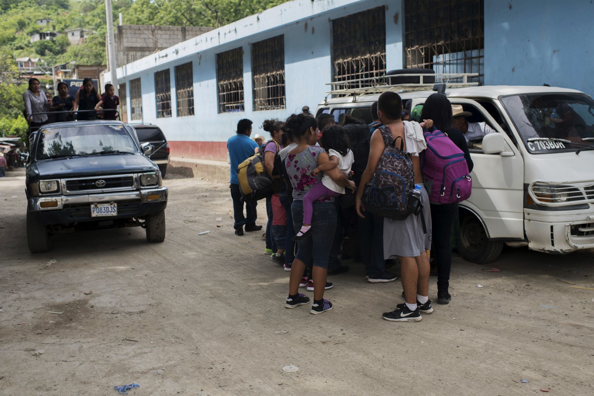 Migrants wait to board a collective taxi in Mexico