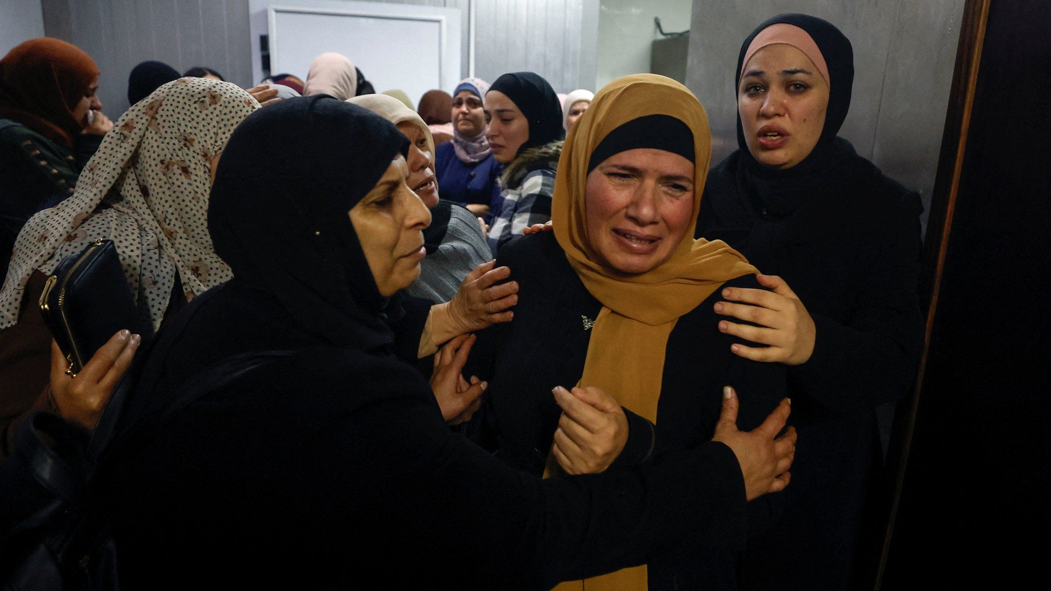 The mother of Palestinian brothers Jawad Rimawi, 22, and Thafer Rimawi, 21, mourns at a hospital in Ramallah before their funerals (29 November 2022)