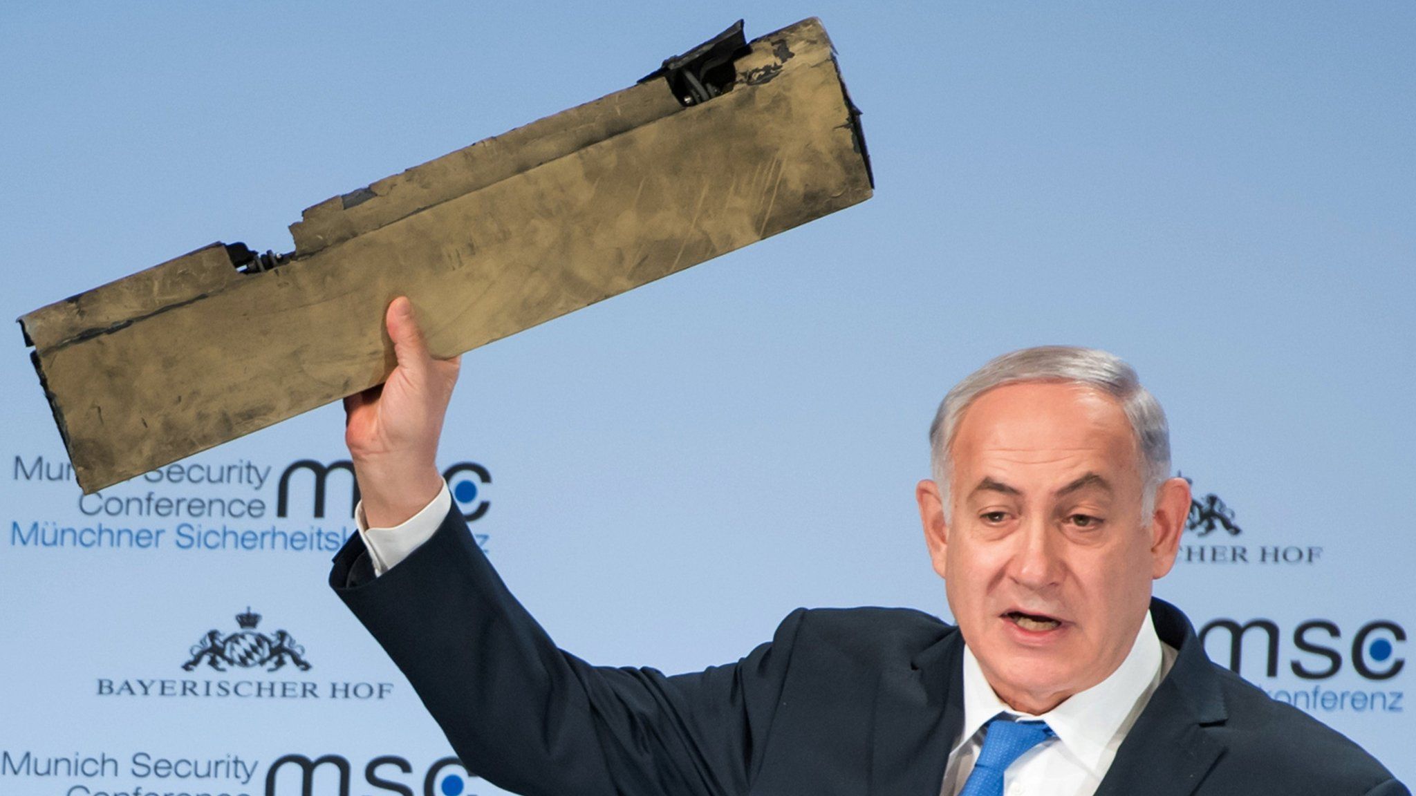 Israeli Prime Minister Benjamin Netanyahu brandishes a piece of an allegedly Iranian drone shot down over Israel as he addresses the participants of the Munich security conference on Sunday