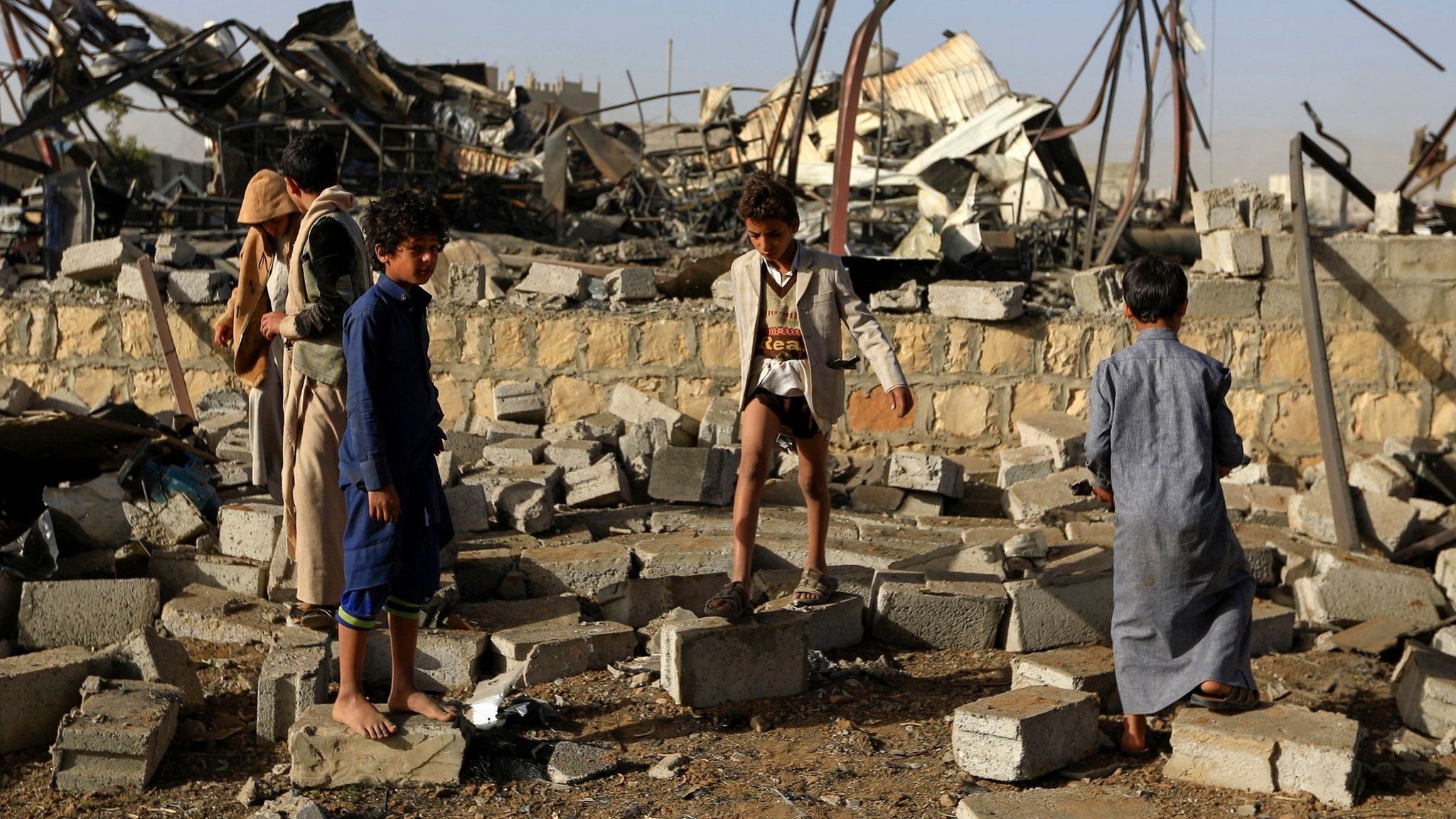 Children collect metal from the site of a destroyed factory following a reported airstrike by Saudi-led coalition in Sanaa, Yemen (20 January 2019)