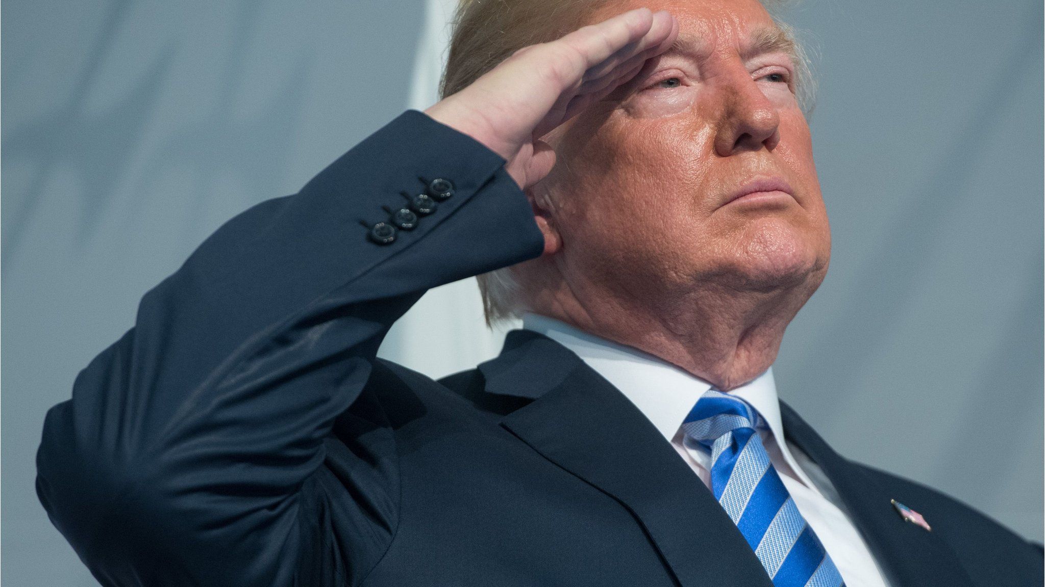 US President Donald Trump salutes during a US Coast Guard ceremony