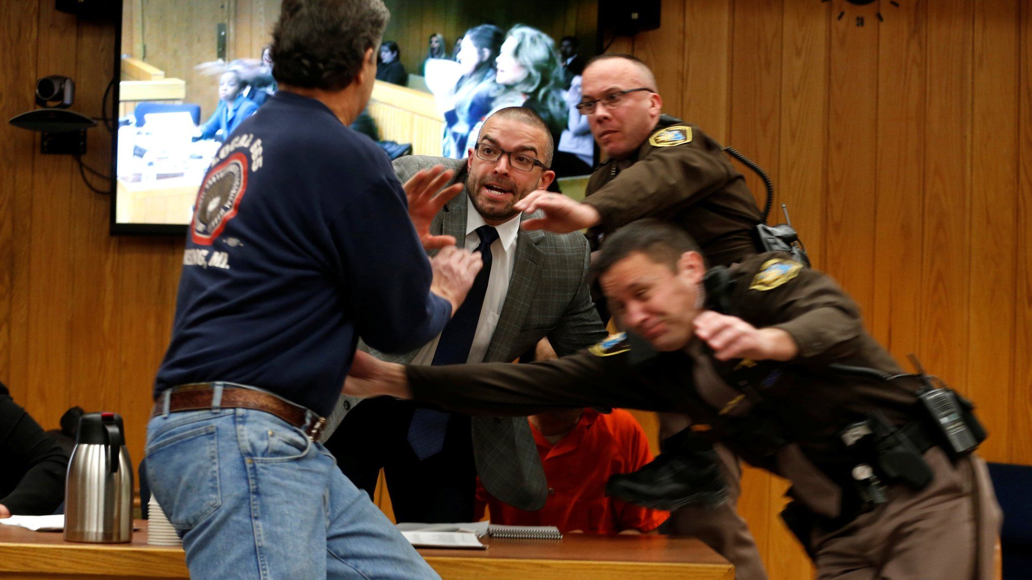 Randall Margraves (L) lunges at Larry Nassar (wearing orange) a former team USA Gymnastics doctor who pleaded guilty to sex abuse in November 2017
