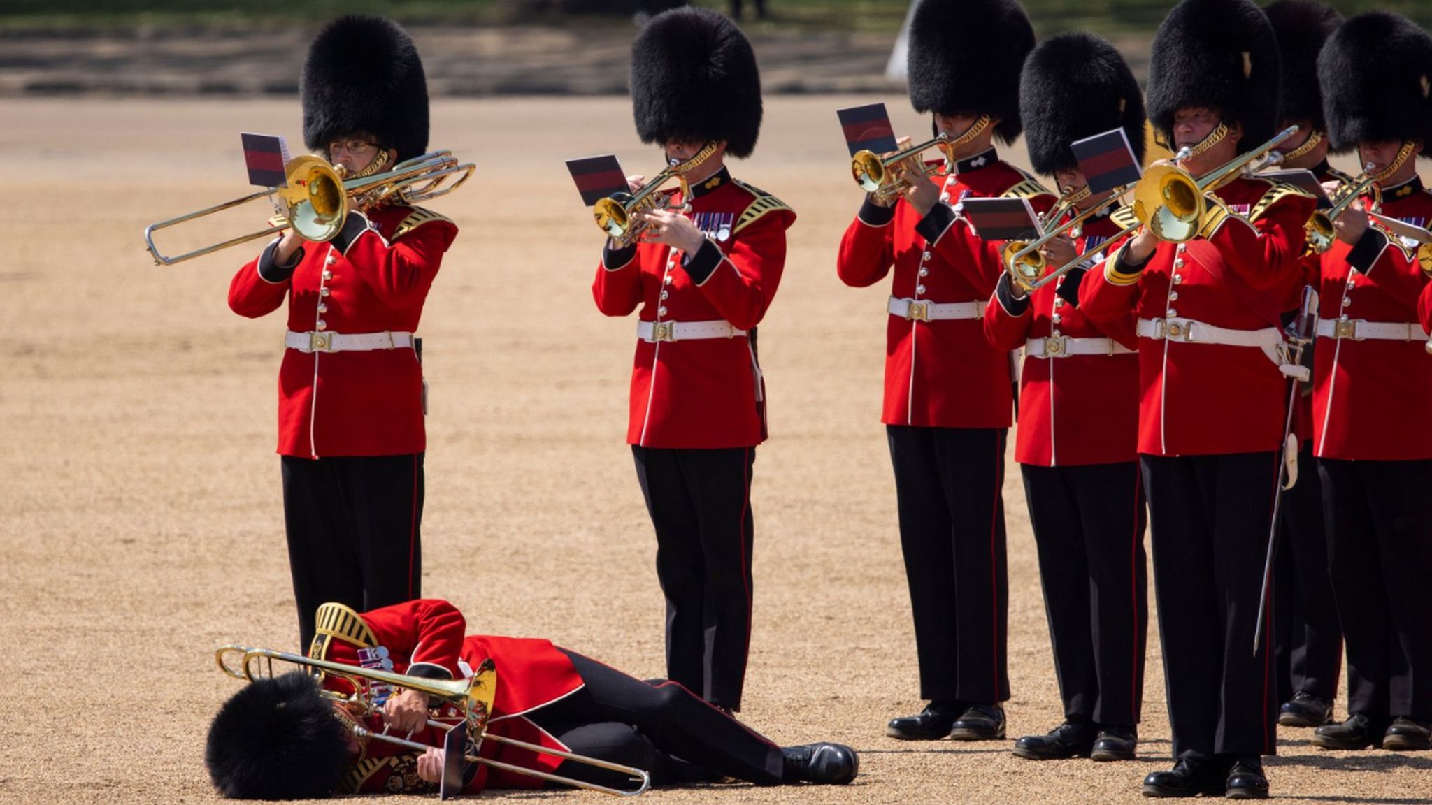 A member of the Massed Bands of the Household Division faints due to heat exhaustion whilst participating in the Colonel's Review at Horse Guards Parade in London