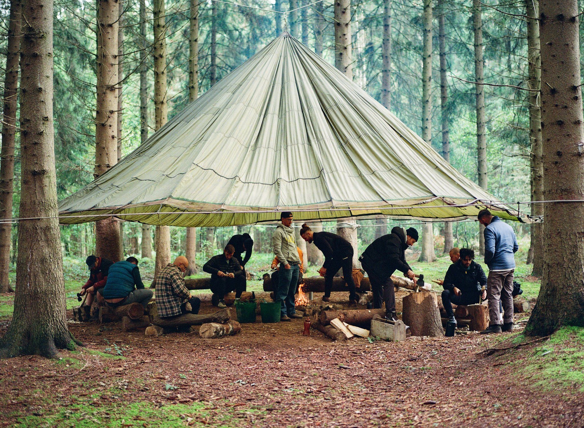 A group of men congregate under a canopy