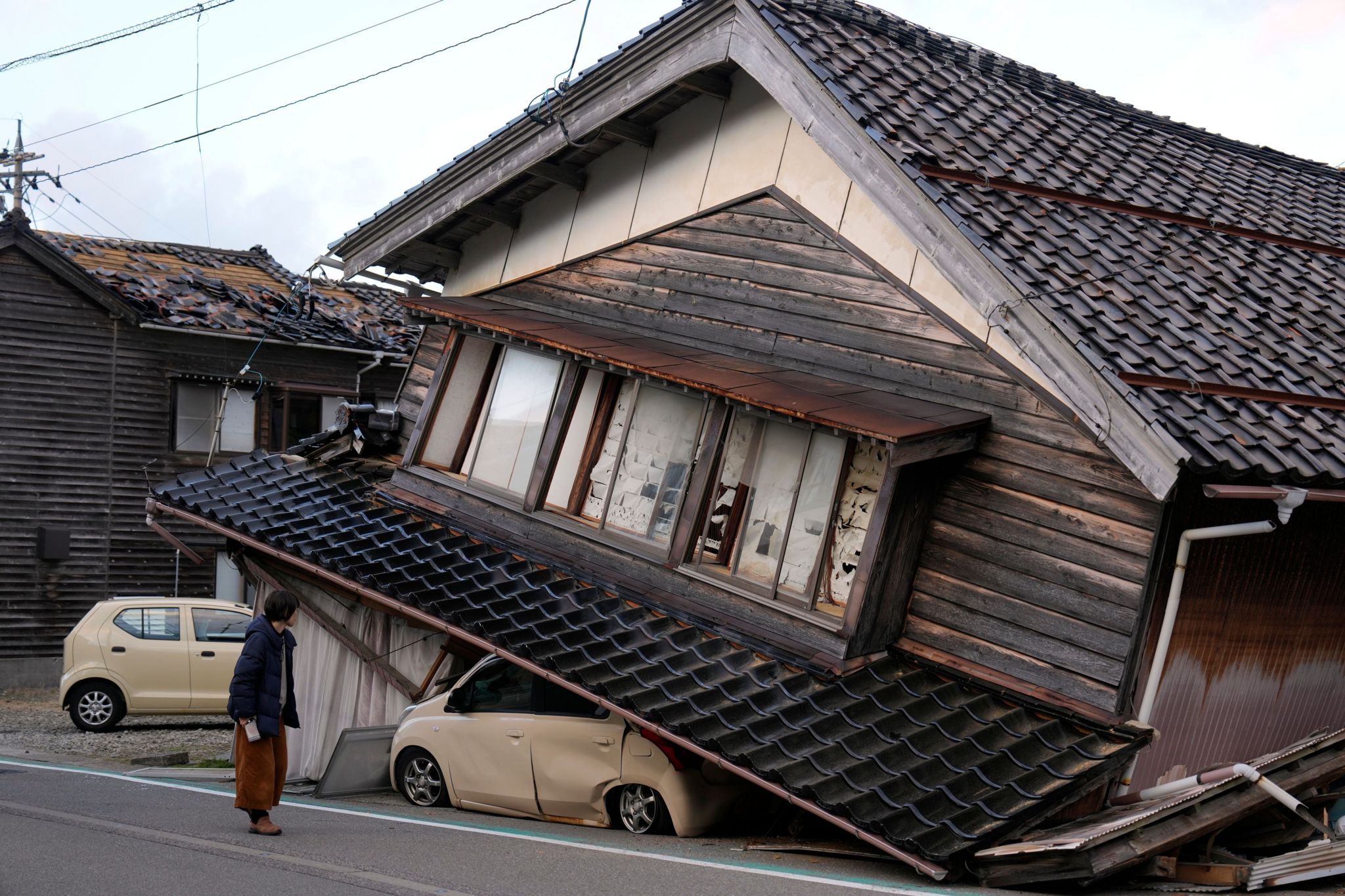 A woman walks past a collapsed house on the Noto peninsula - the epicentre of the quake