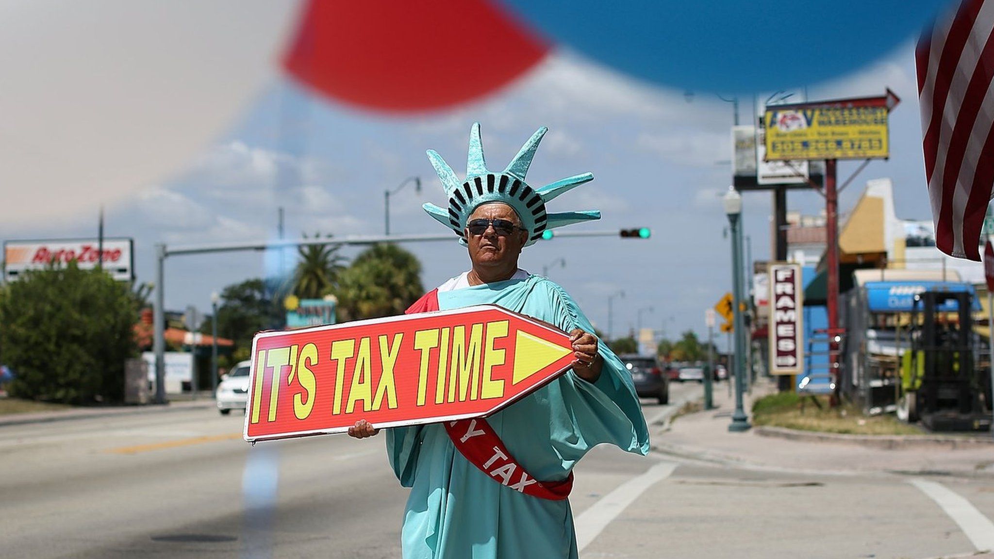 Armanda La Rosa directs people to the Liberty Tax Service office as the deadline to file taxes looms on April 15, 2016 in Miami, Florida.