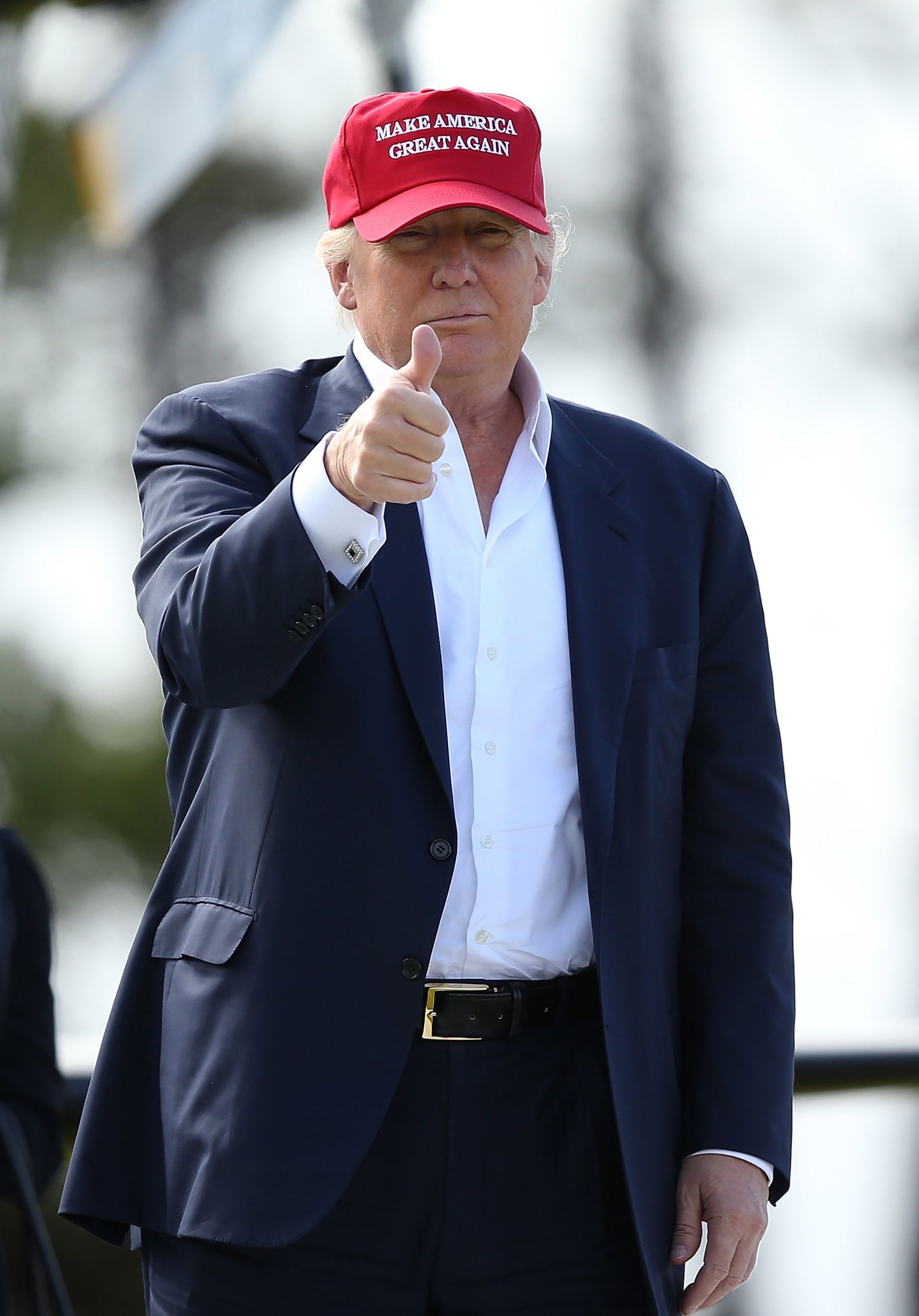 Donald Trump, making a thumbs-up gesture while wearing a cap with slogan - Make America Great Again, July 2015