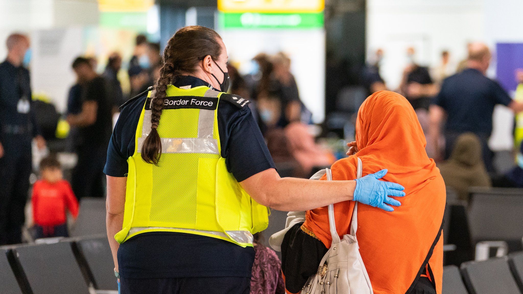 A Border Force official welcomes a refugee