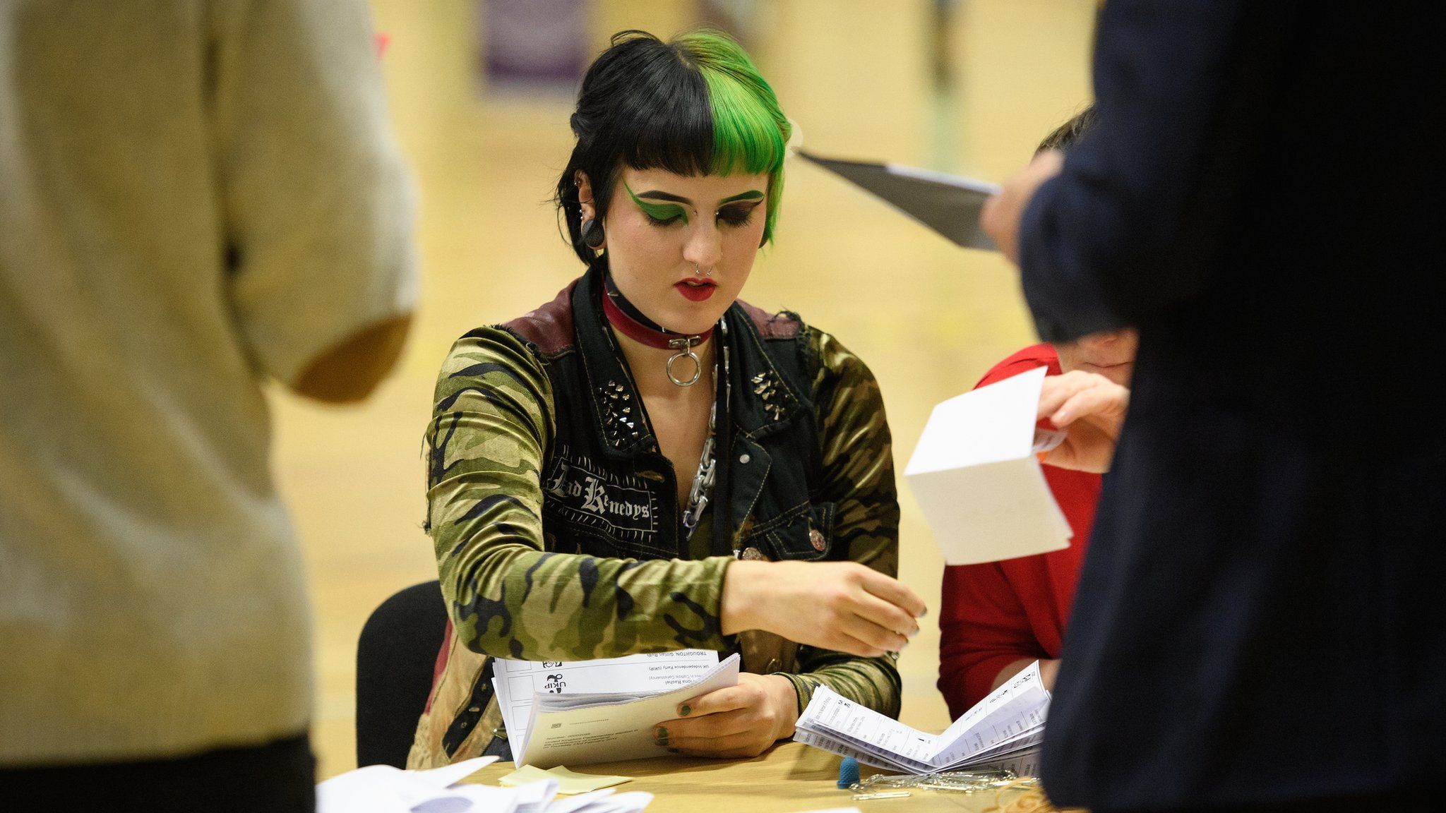 A young person counts ballots at a polling station