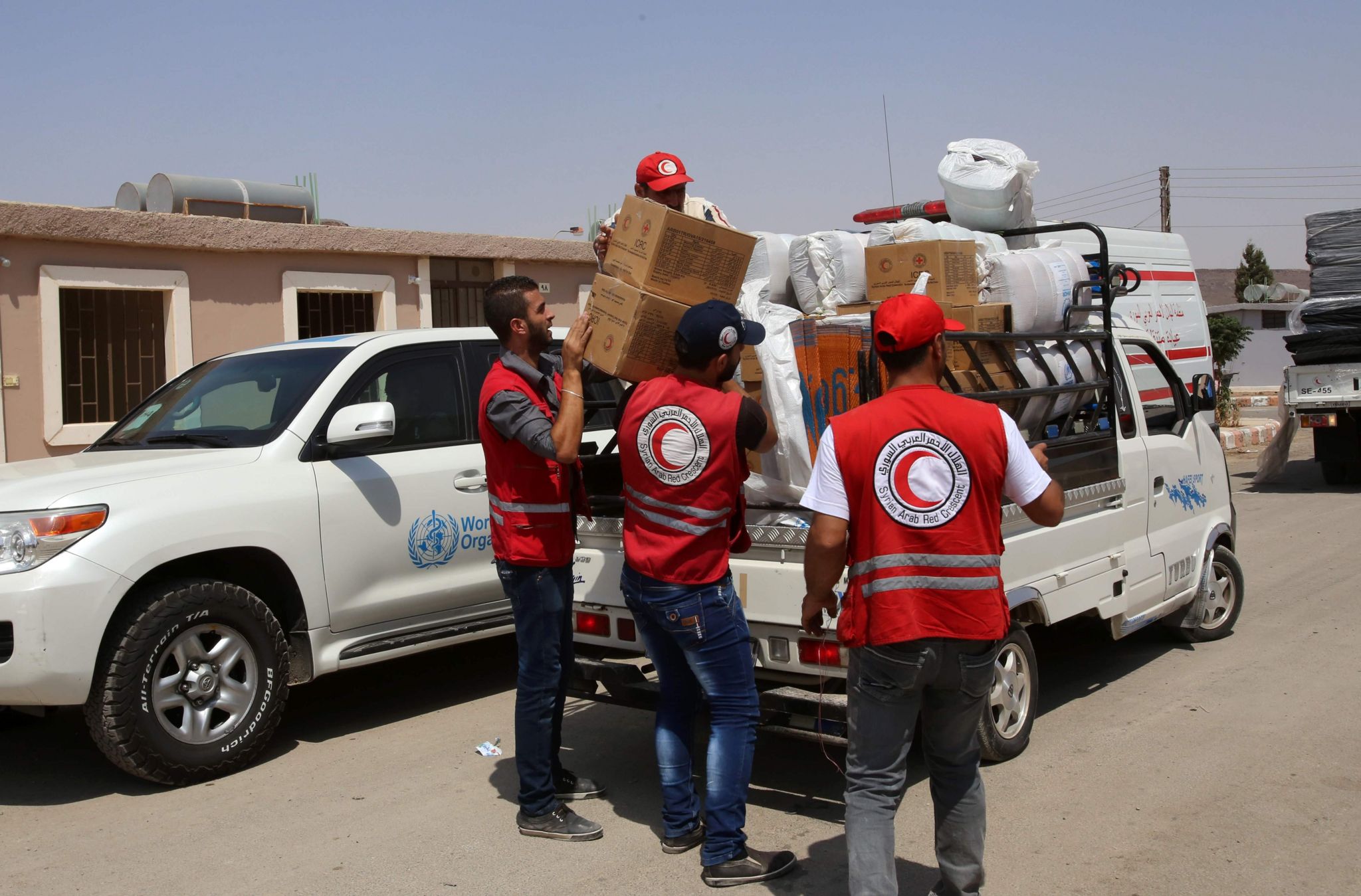 SARC workers unload food for residents who were evacuated from Darayya on August 27, 2016